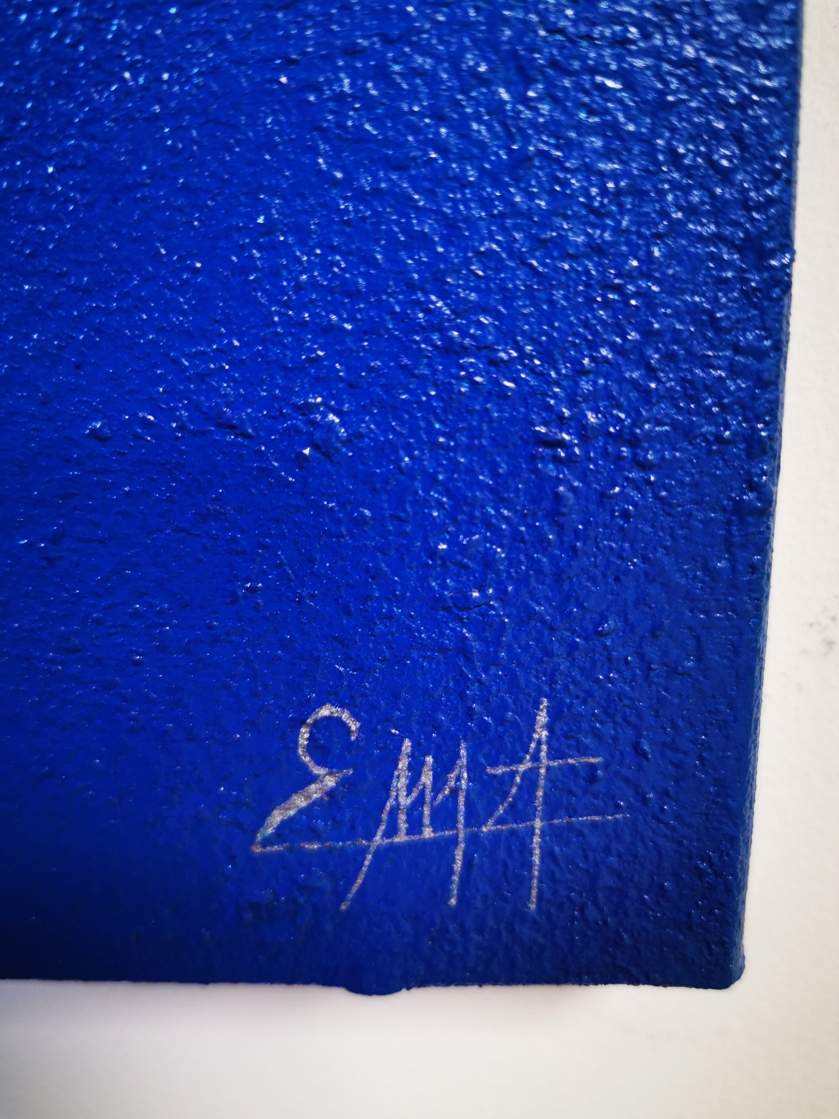 A large blue painting hanging on a wall.