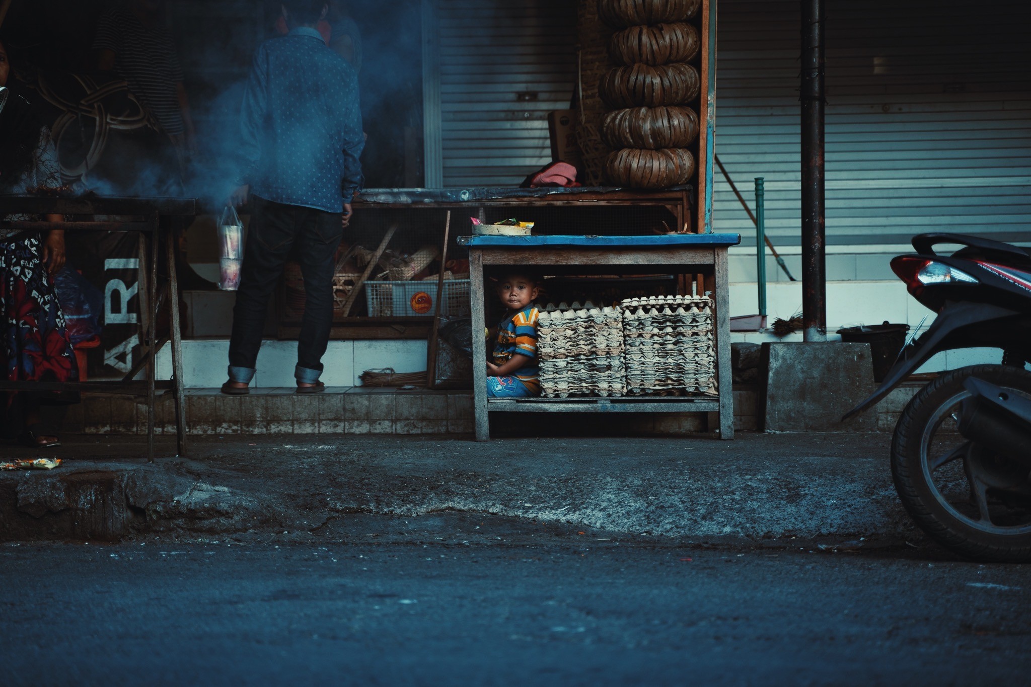 A man standing next to a small child in front of a store.