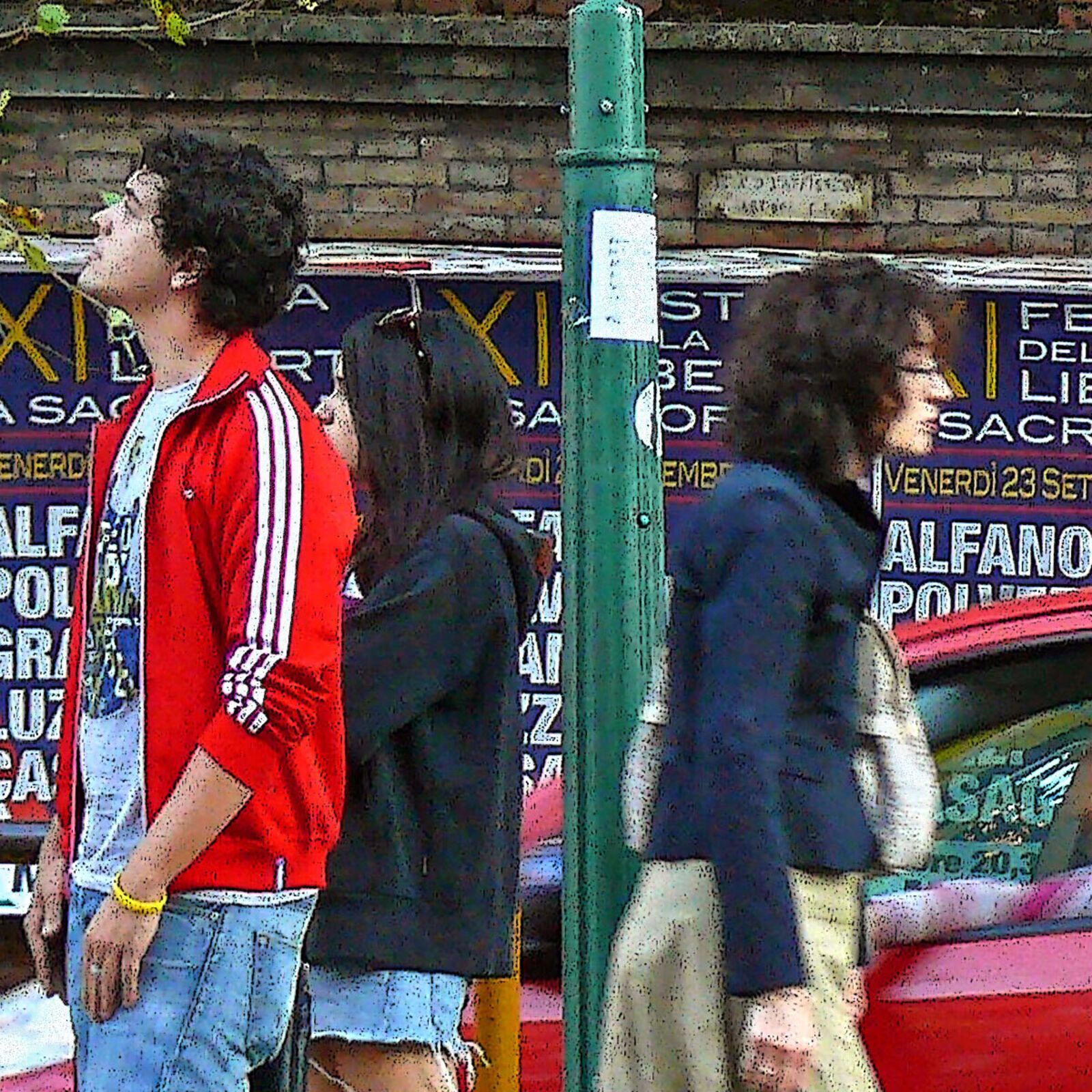A group of people sitting on a bench in front of a bus stop.