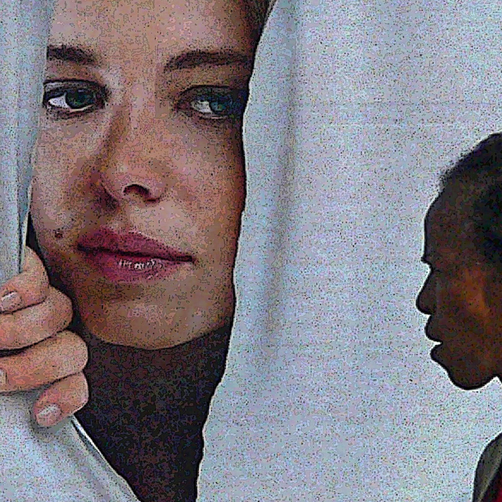 A woman walking past a bus with a poster on the back.