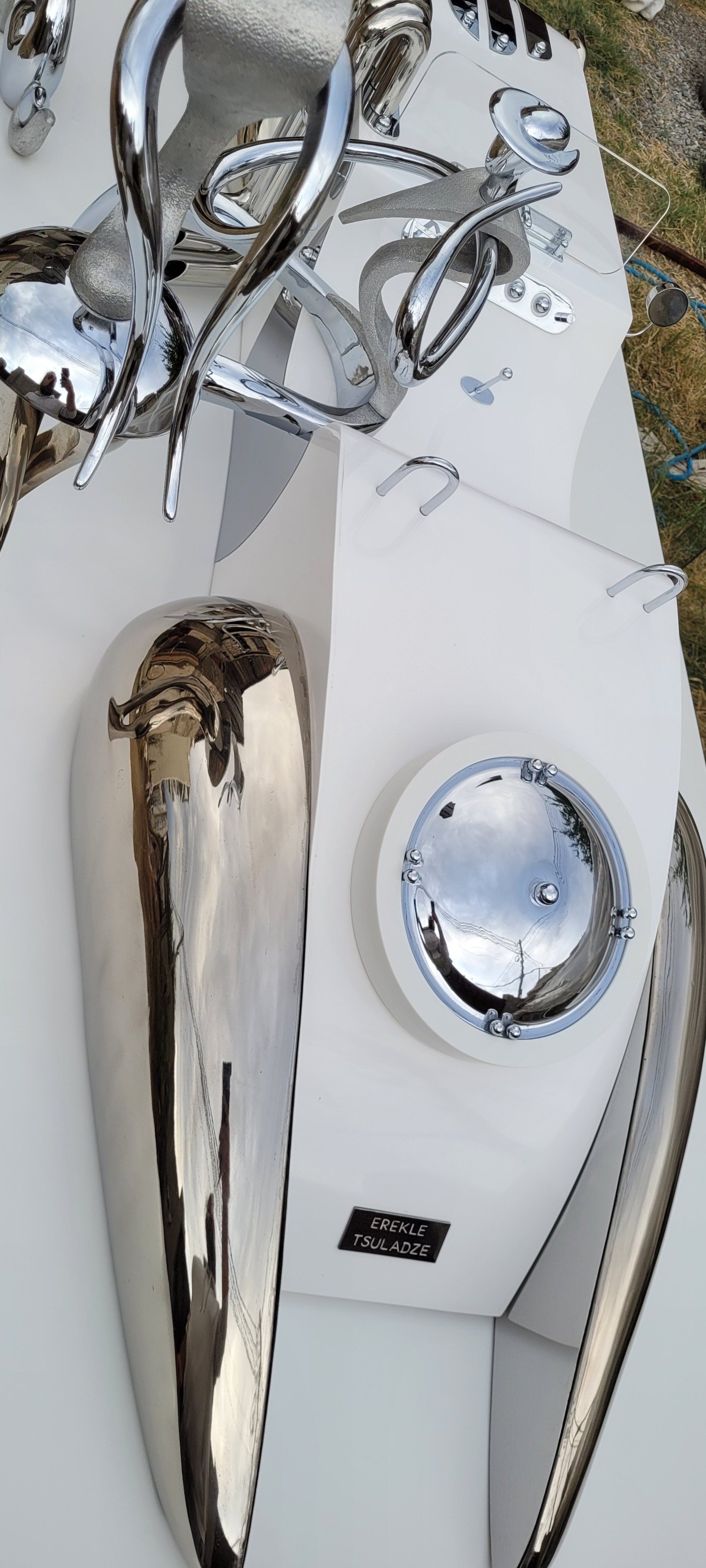 A collection of polished chrome sculptures displayed on a white surface.