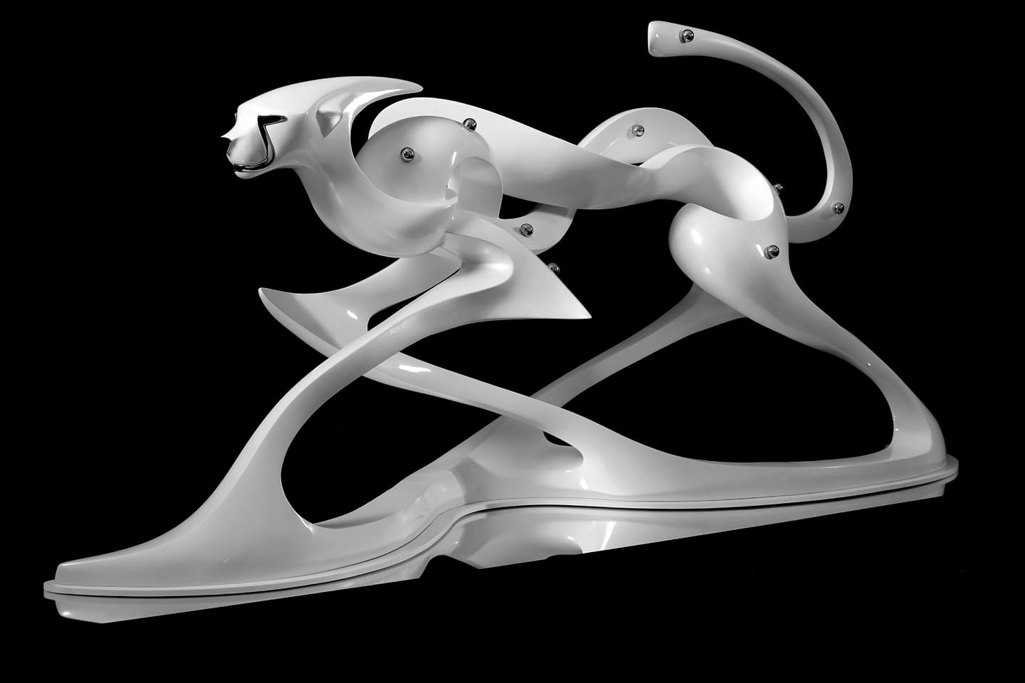 A white sculpture of a cat on a black background.