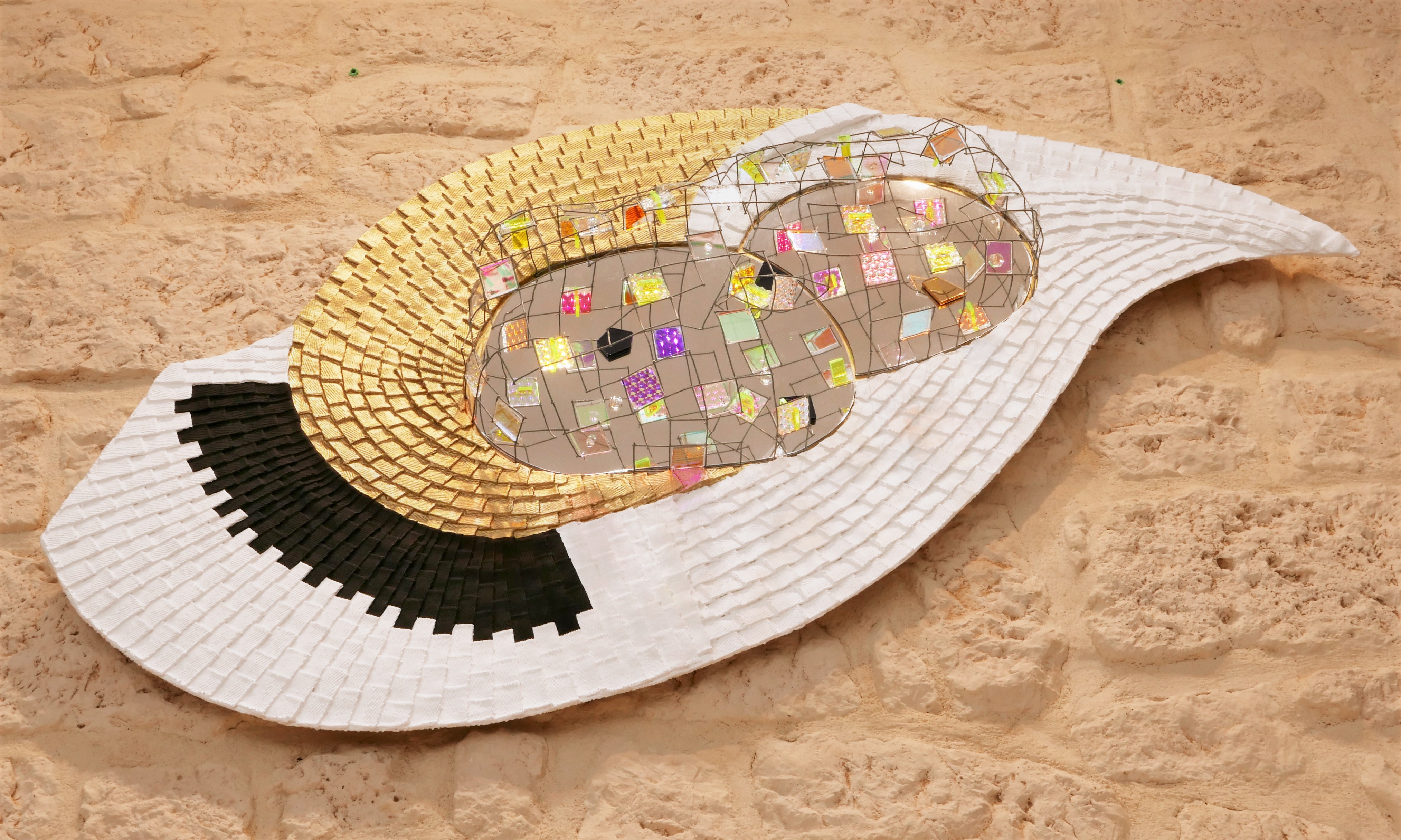 A white hat with a mirror ball on top of it.