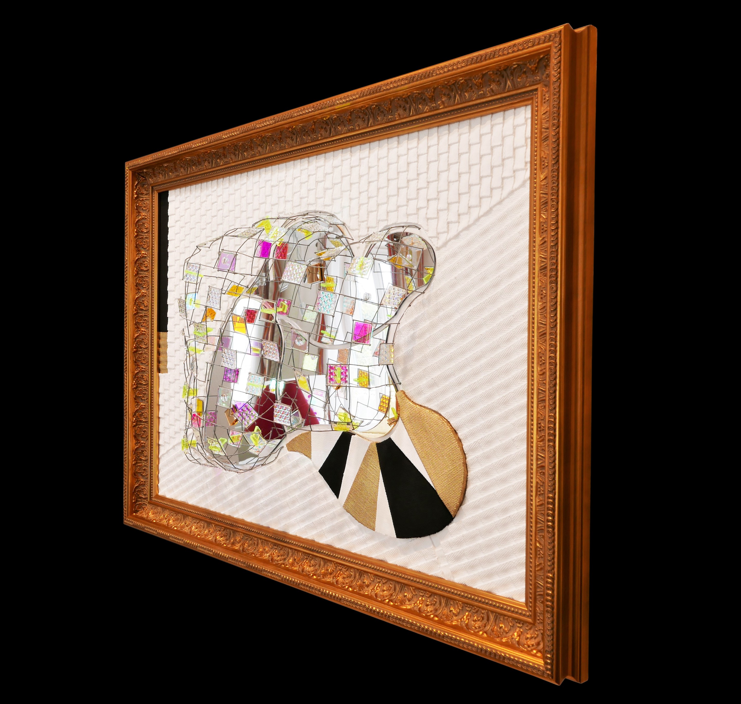 A picture of a mirror sculpture in a gold frame.