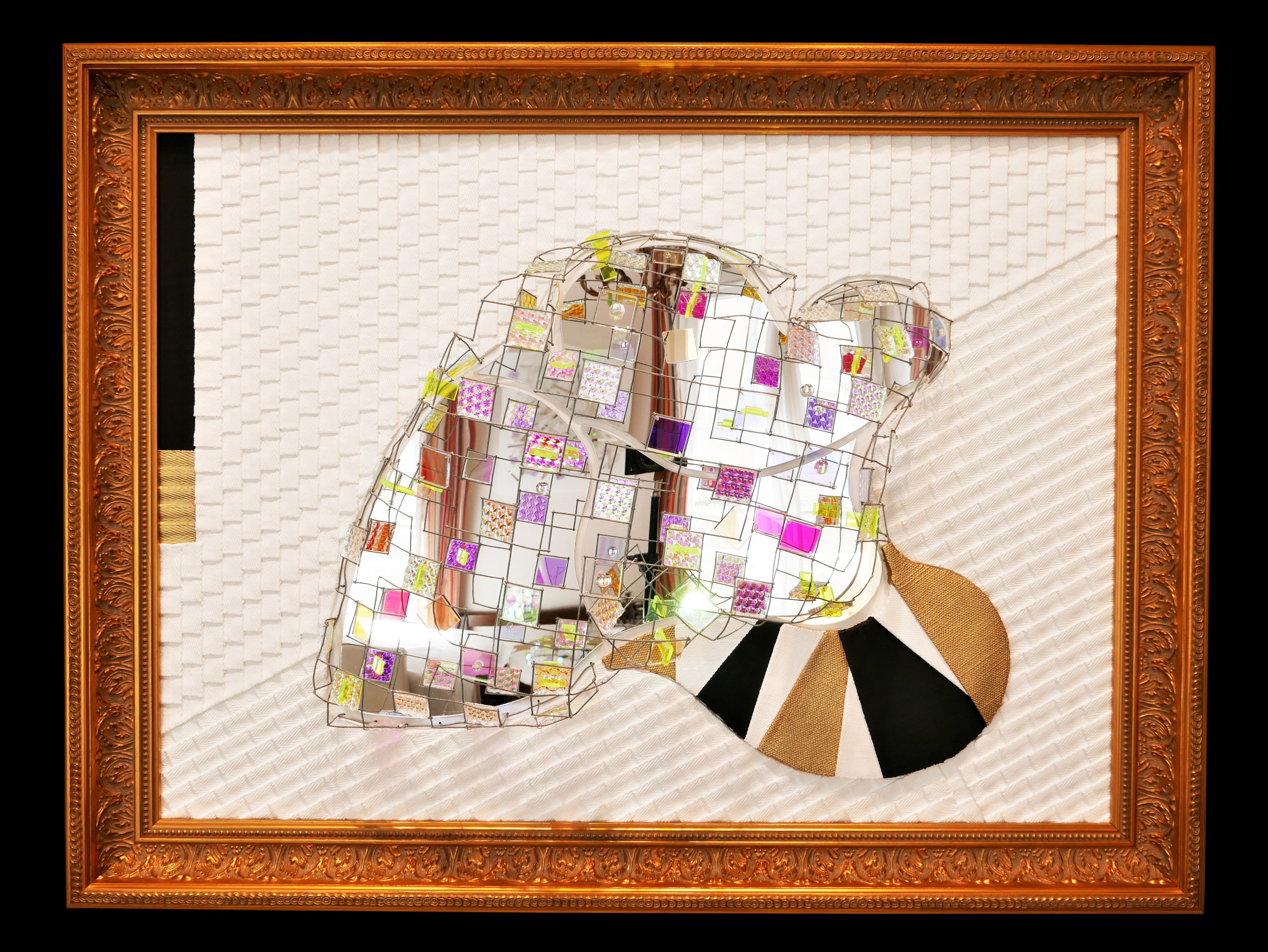 A picture of a mirror sculpture in a gold frame.