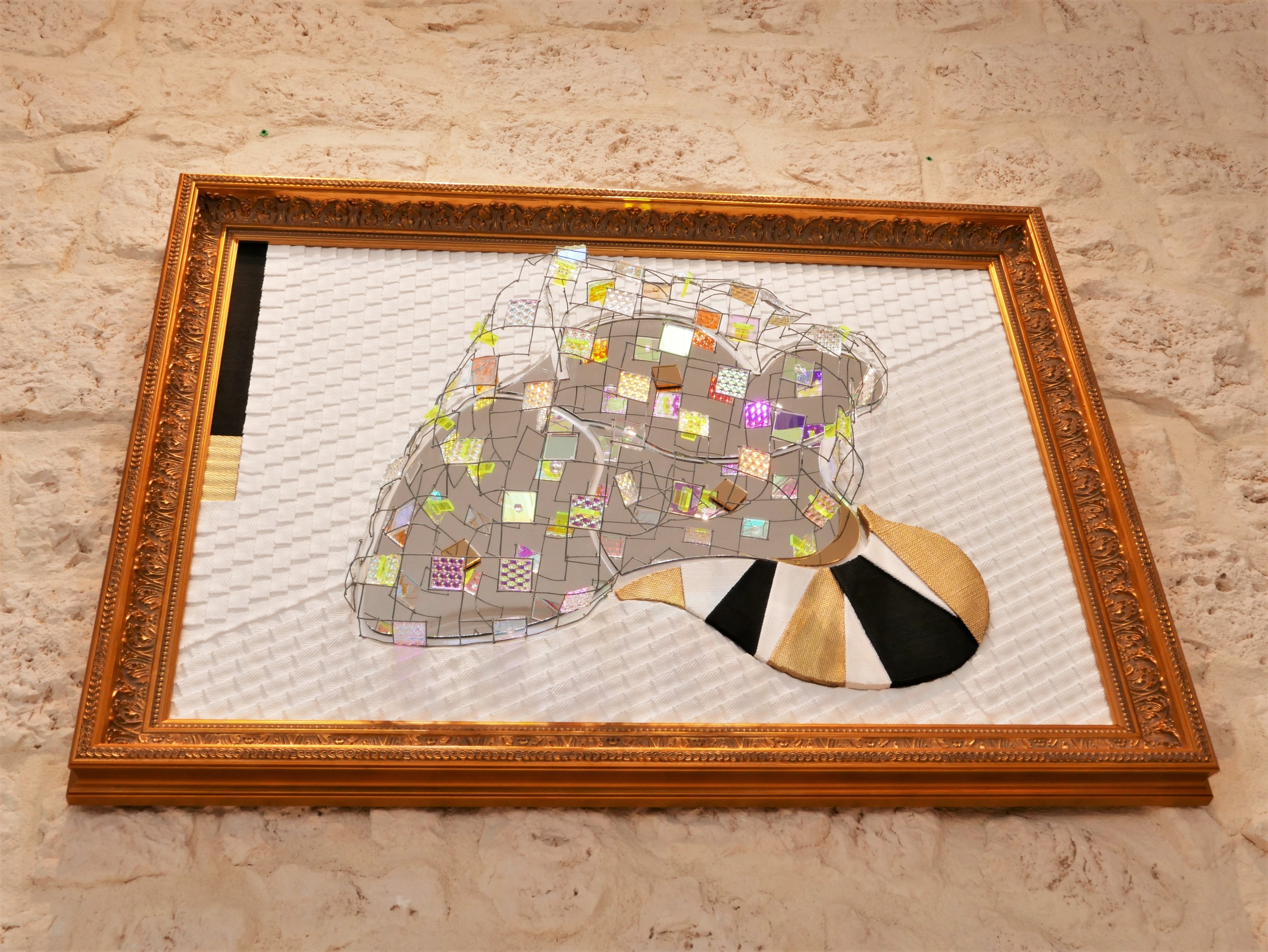 A picture of a mirror sculpture in a gold frame.