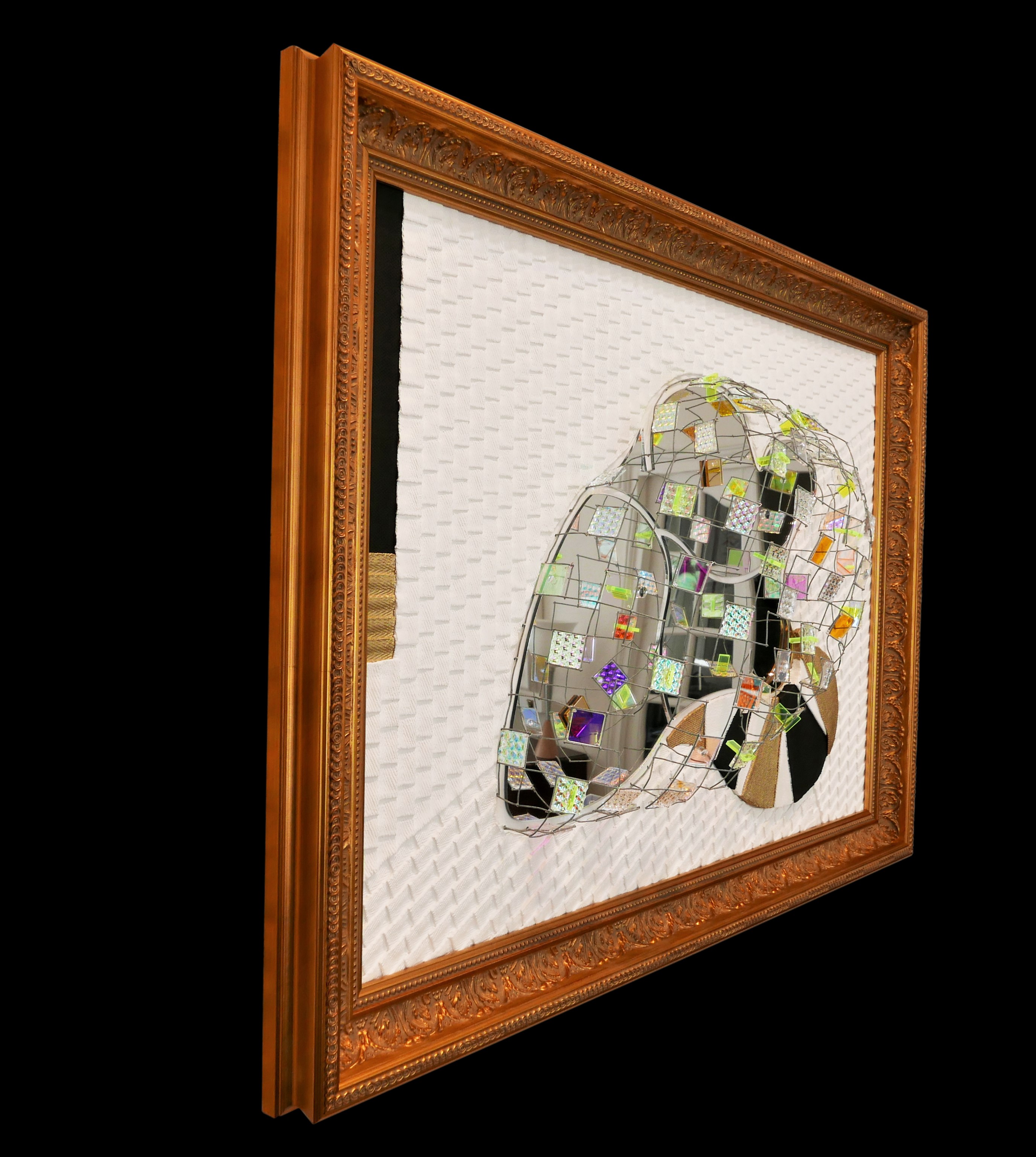 A picture of a mirror sculpture in a gold frame.