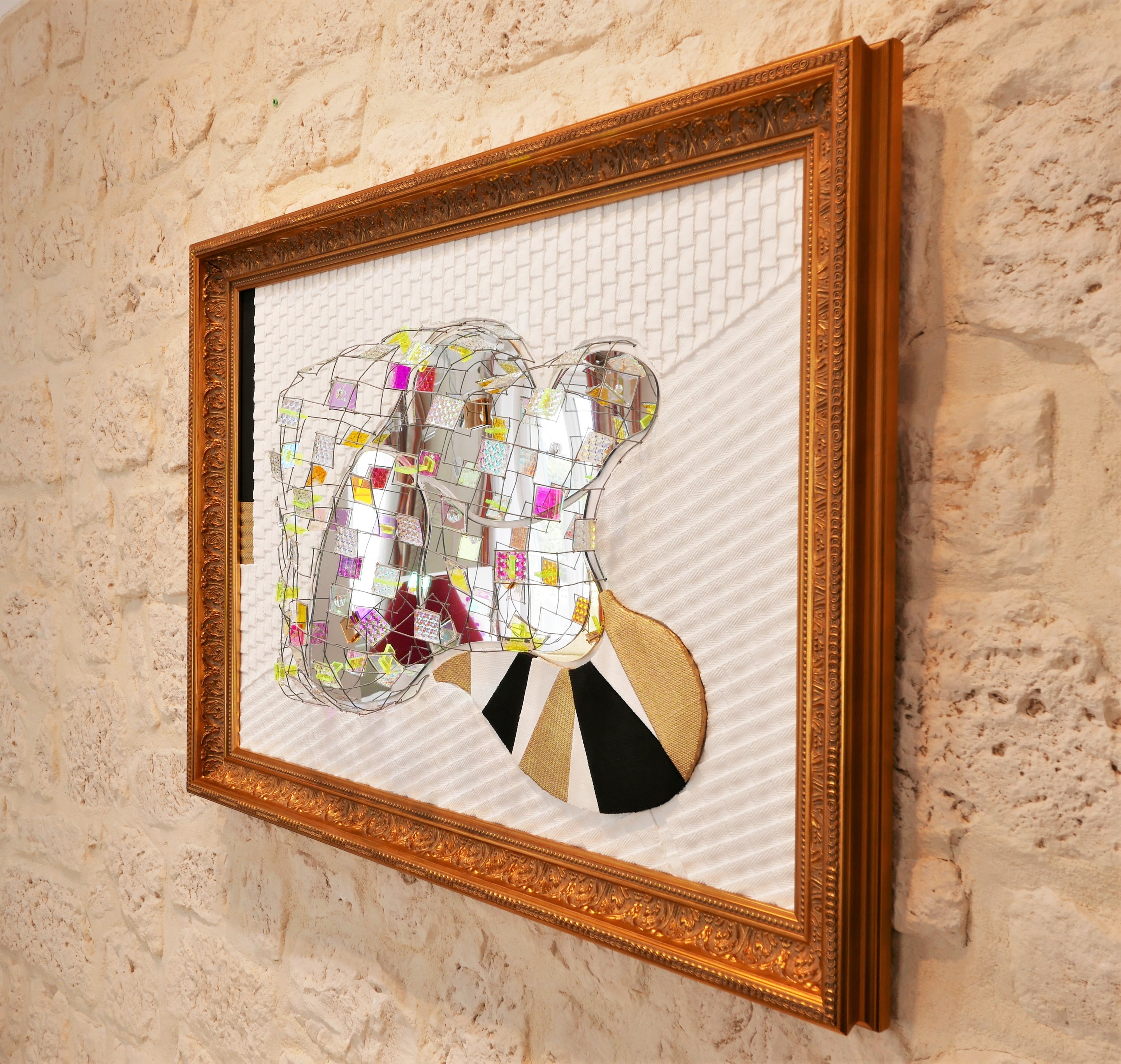 A picture of a mirror sculpture in a gold frame.