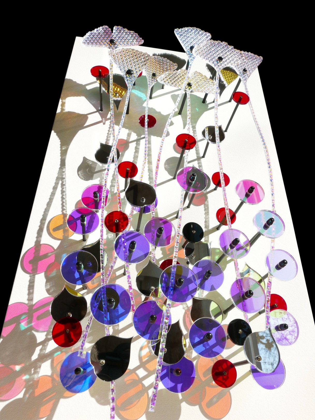 A bunch of cds hanging from a string on a wall.