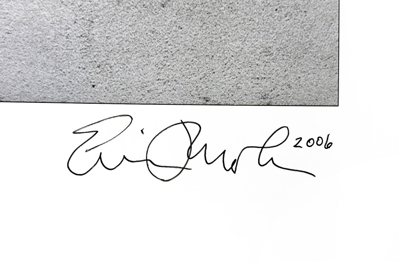 A black and white photo of a man standing in front of a wall.