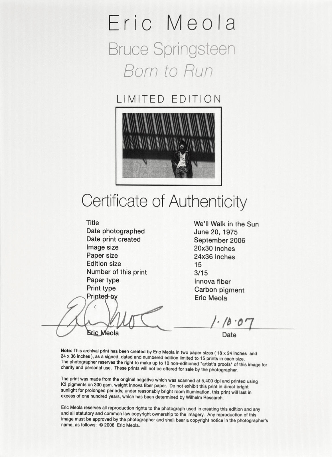 A black and white photo of a man standing in front of a wall.