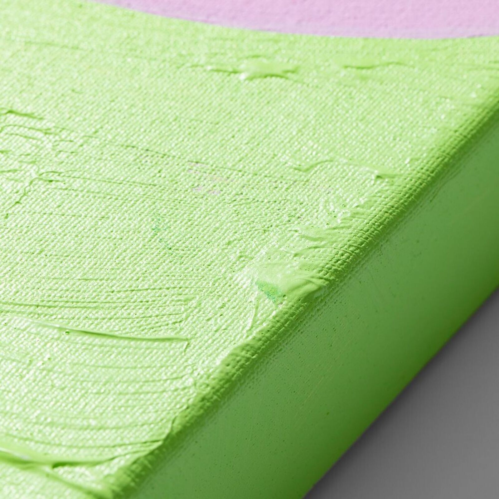 A painting on a wall with a pink and green background.