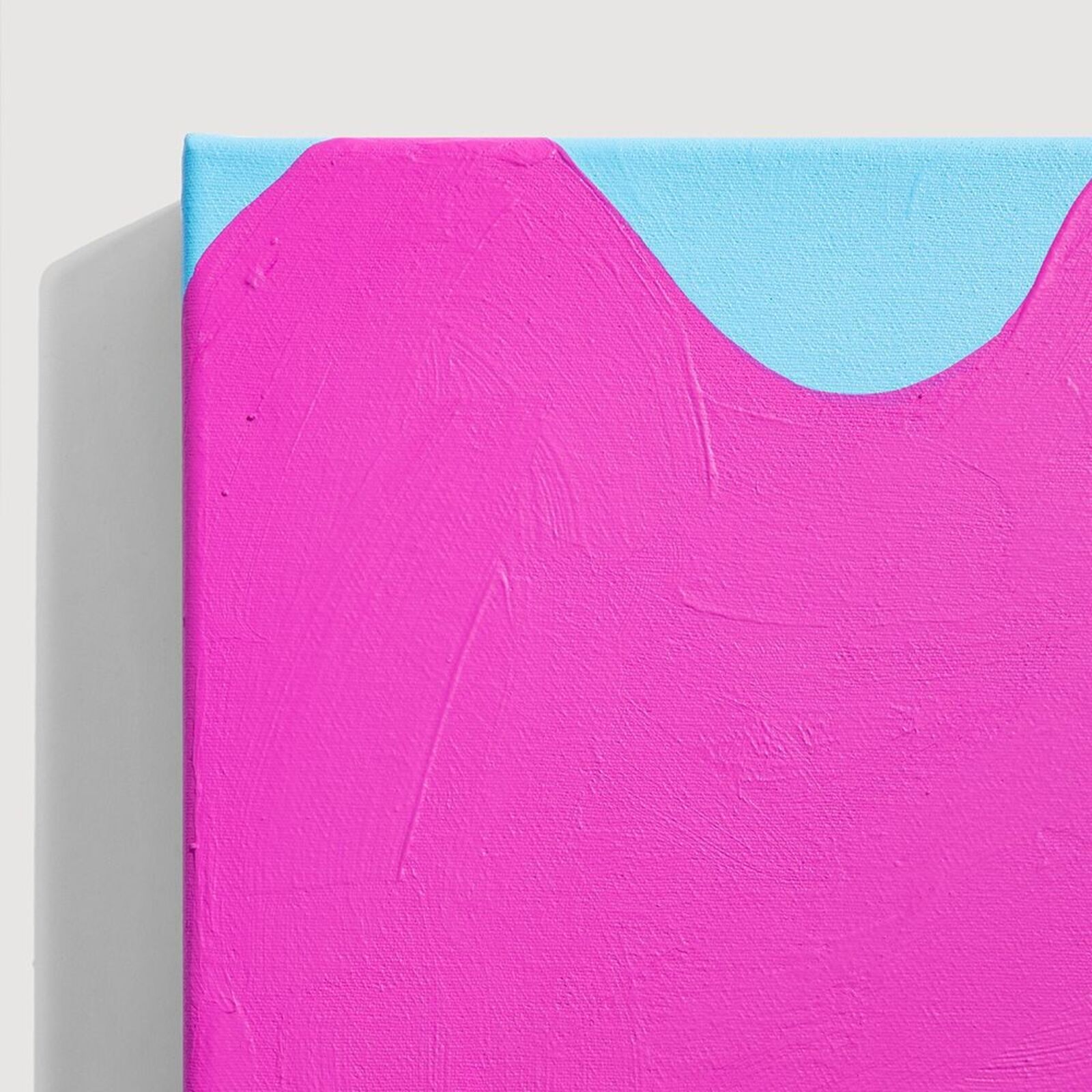 A pink and blue painting on a white wall.