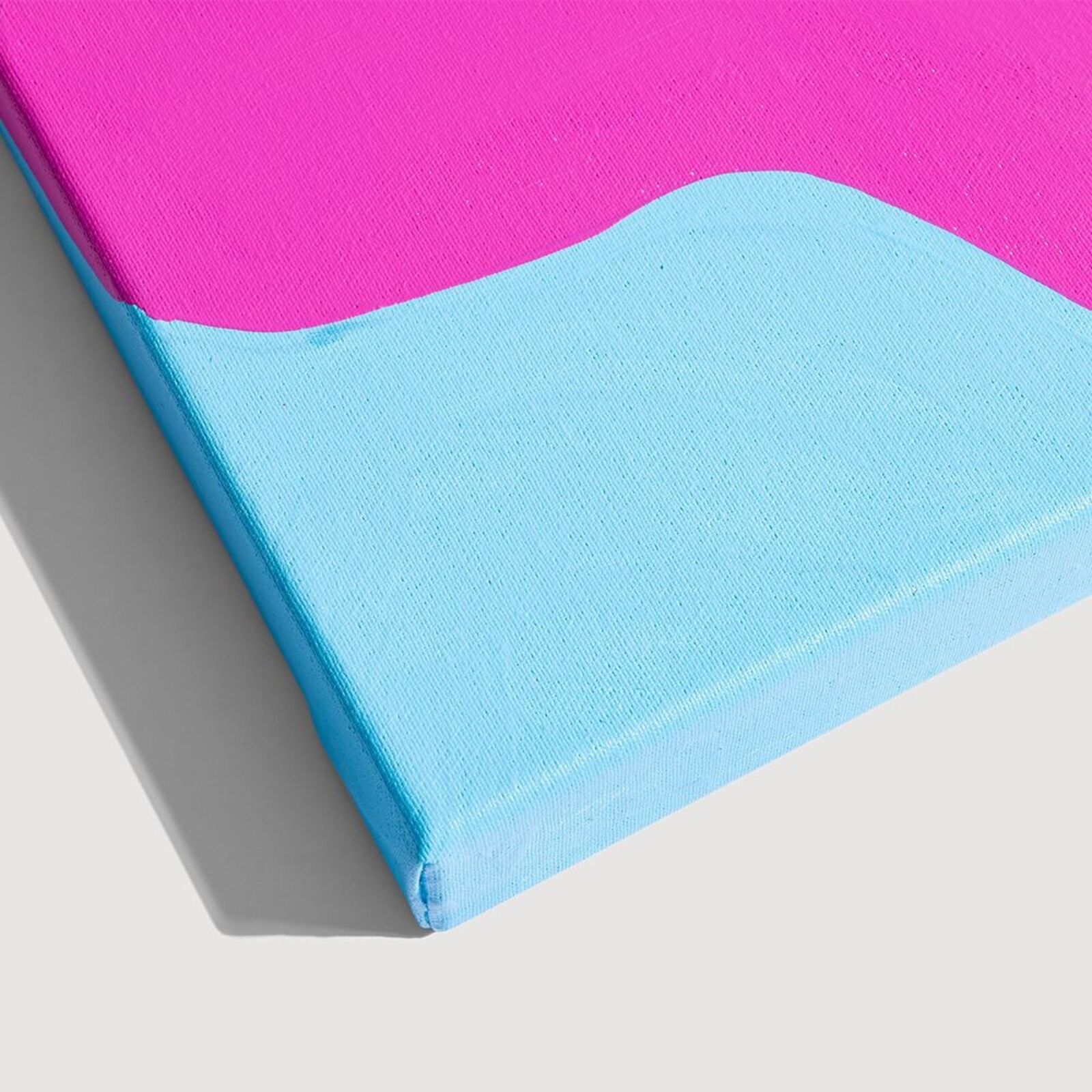 A pink and blue painting on a white wall.