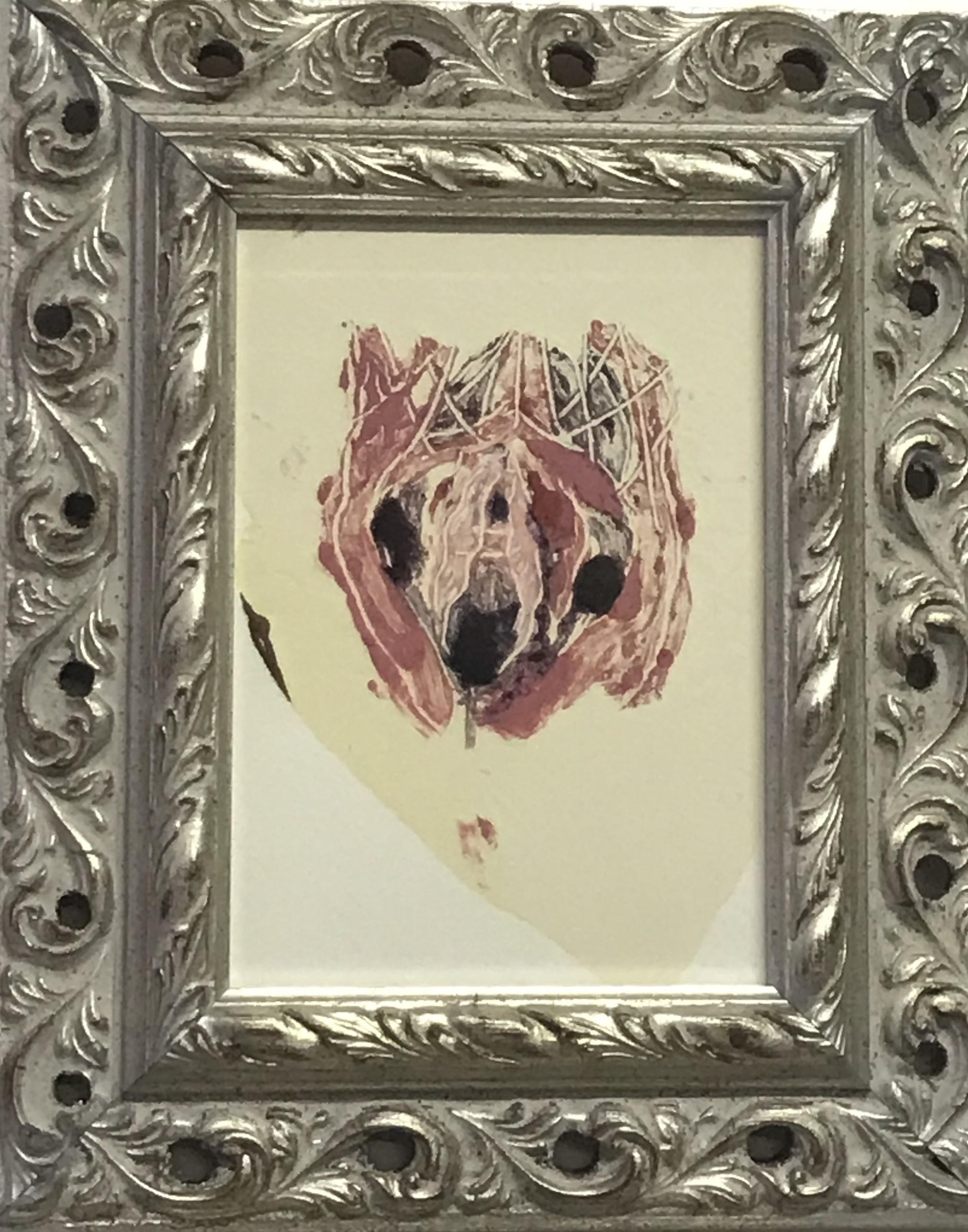 A picture of a dog's head in a silver frame.