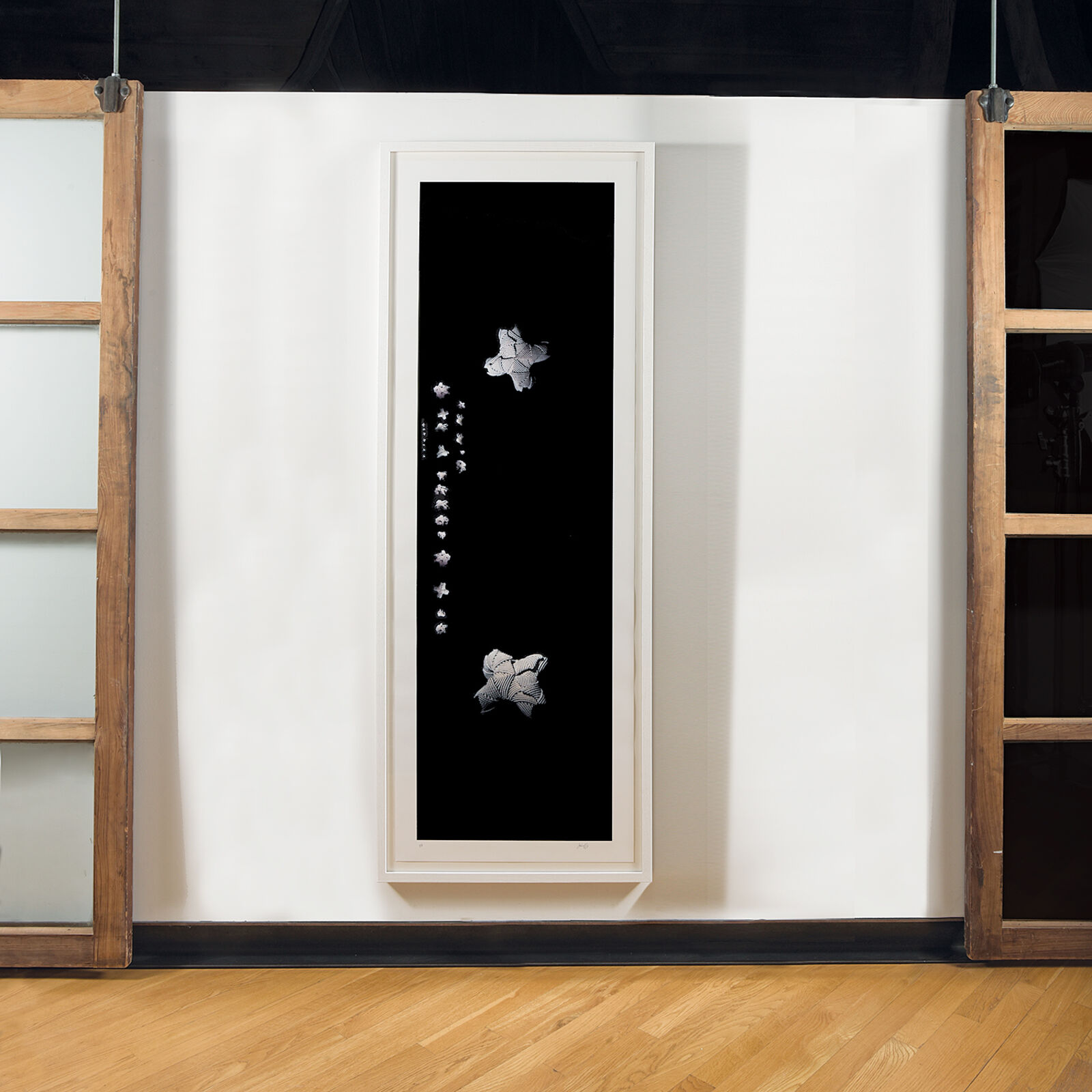 A black and white painting hanging on a wall in a room.