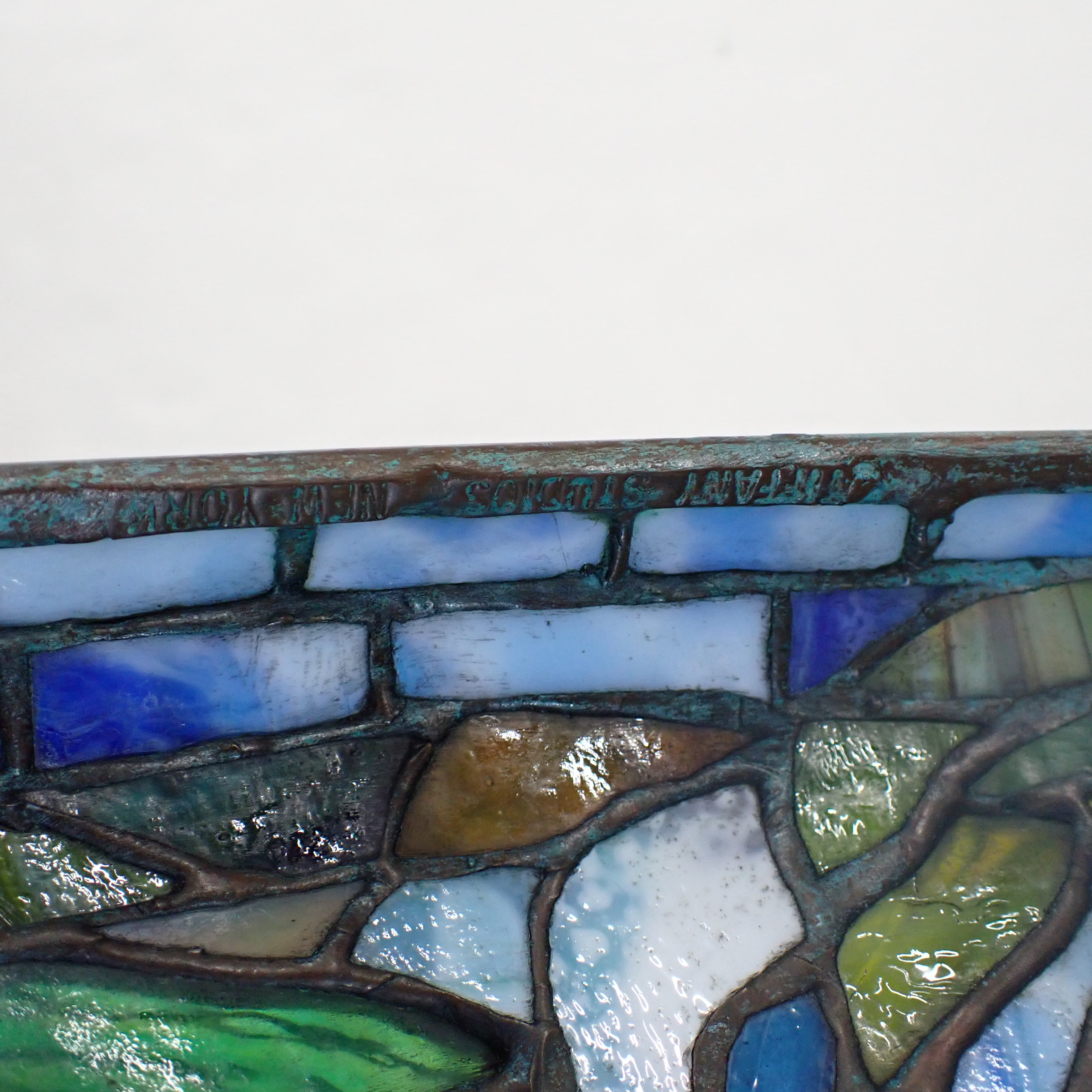 A stained-glass table lamp featuring a vibrant underwater scene with fish and aquatic plants.
