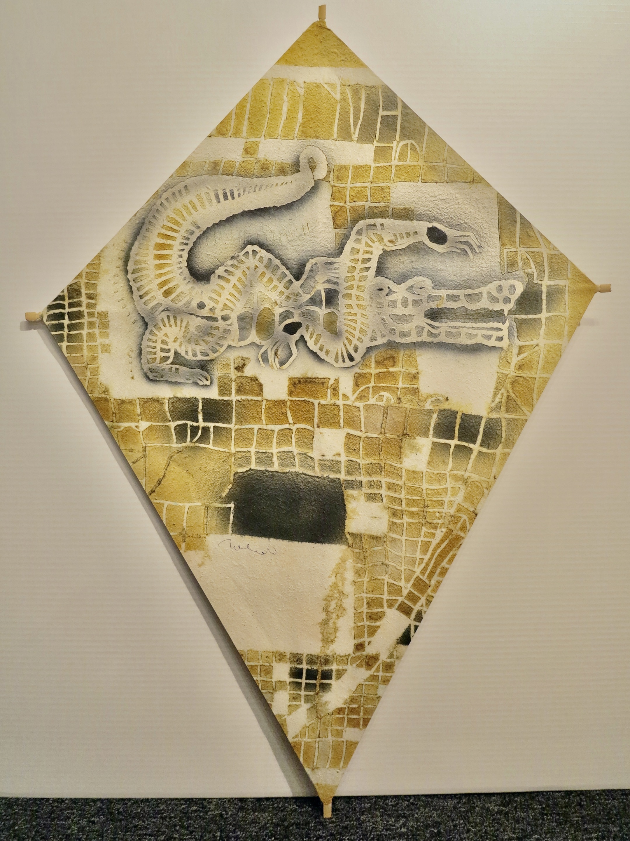 A painting of a snake on a piece of paper on a wall.