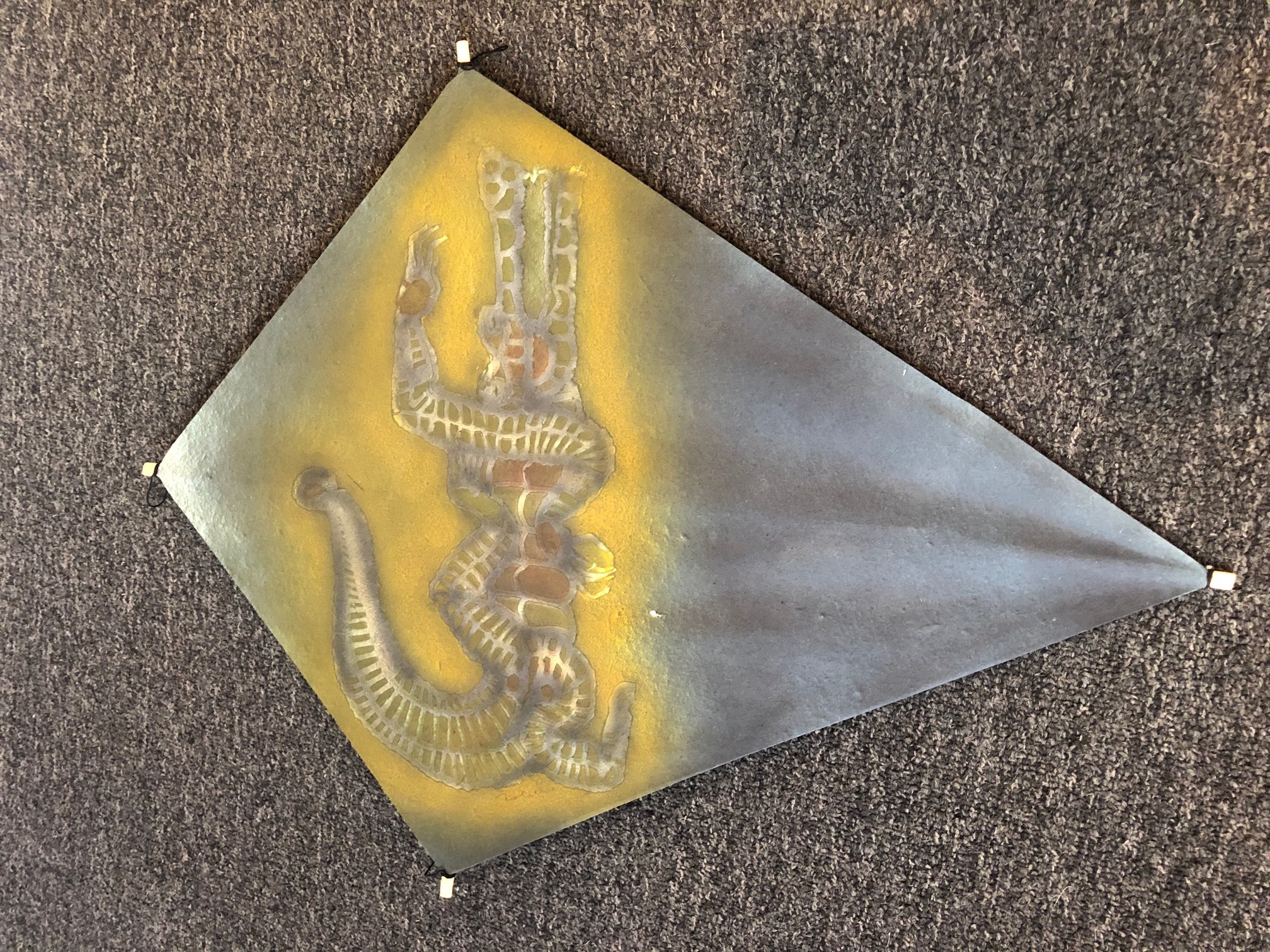 A metal triangle with a snake on it. 