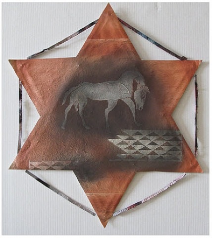 A metal star with a horse on it. 