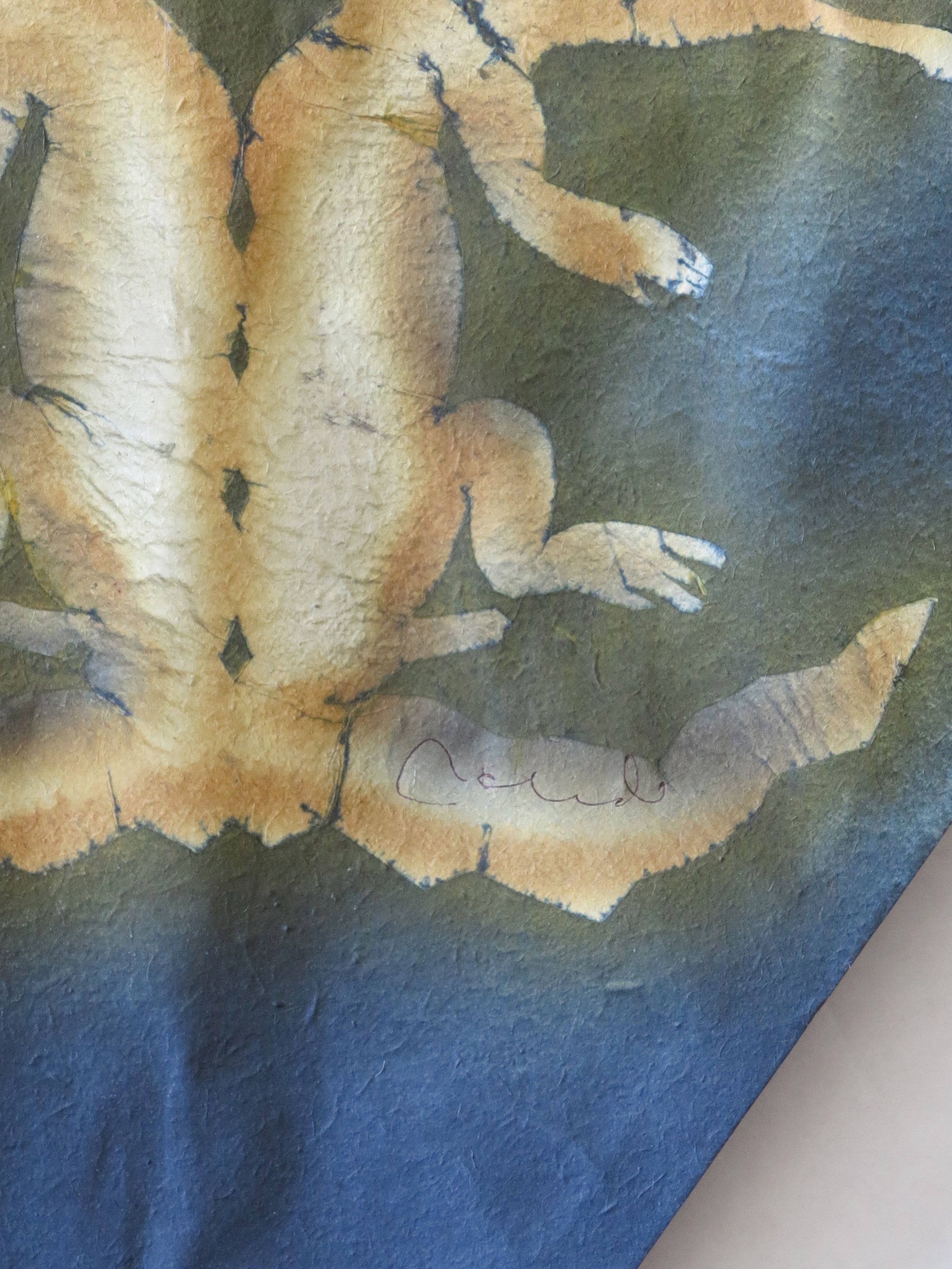 A black and gold dragon on a blue and gold kite hanging on a wall.