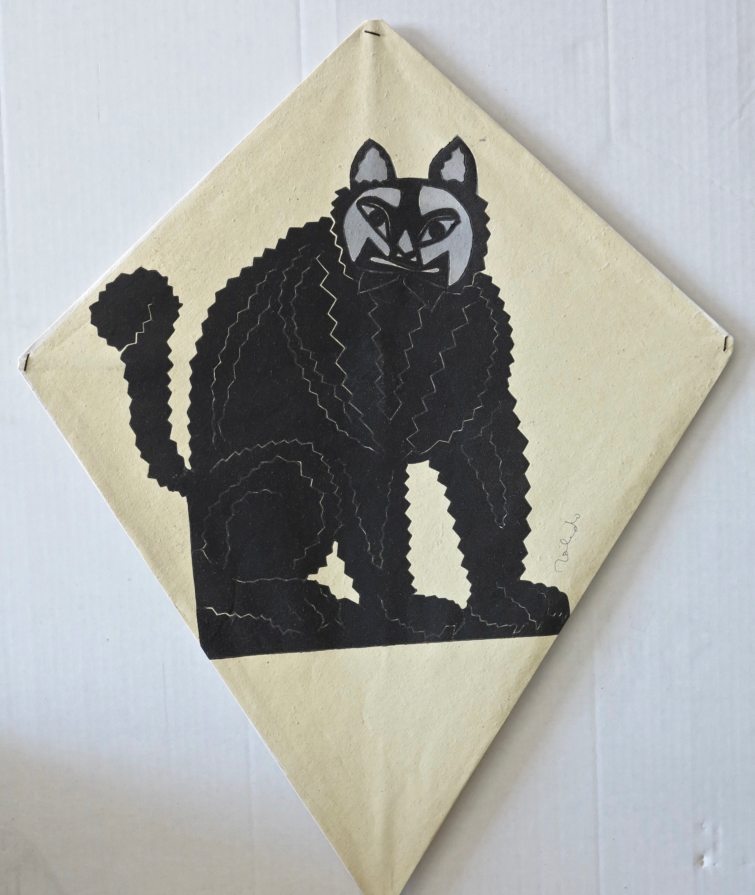 A black and white drawing of a cat on a piece of paper.