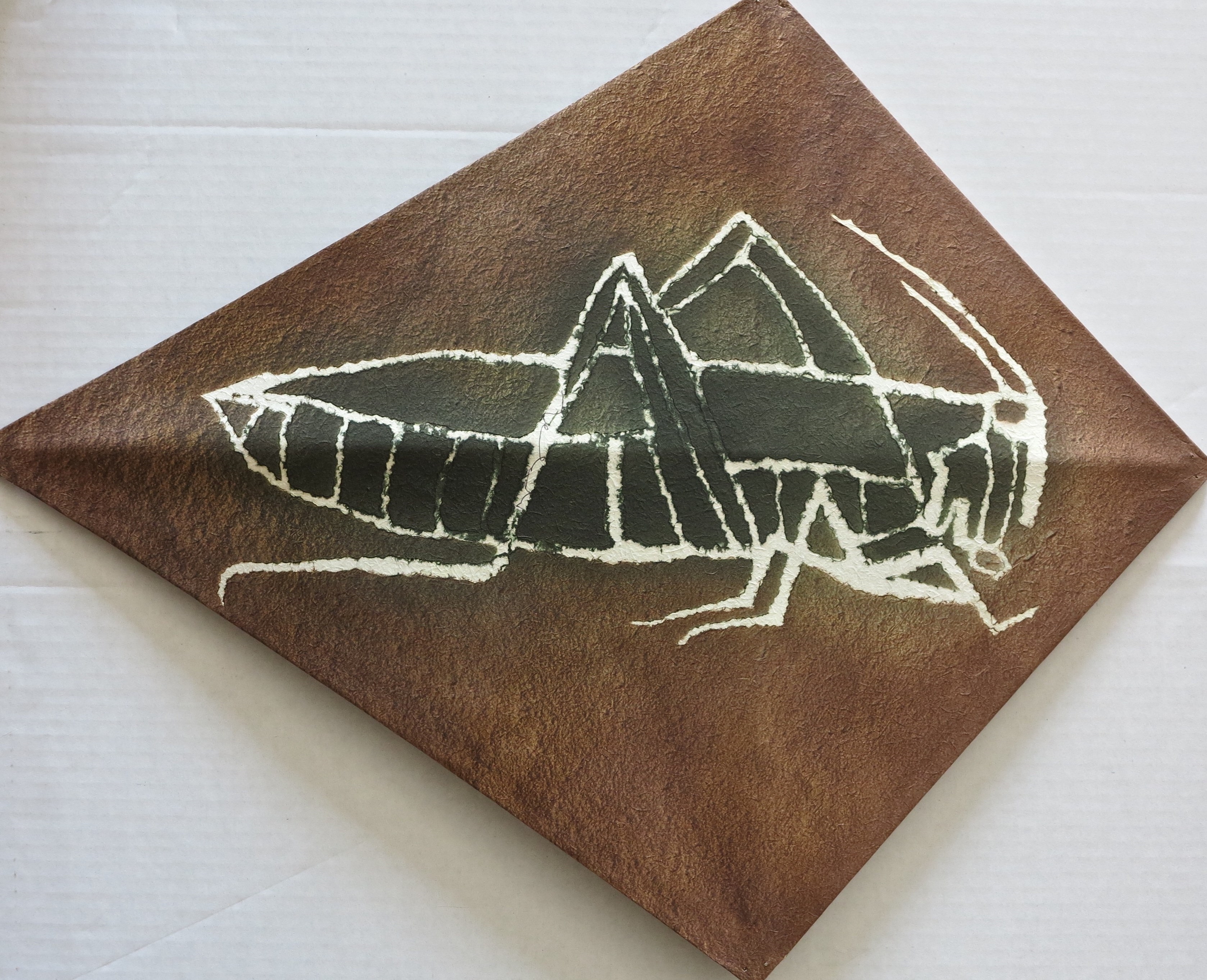 A drawing of a grasshopper on a piece of paper.