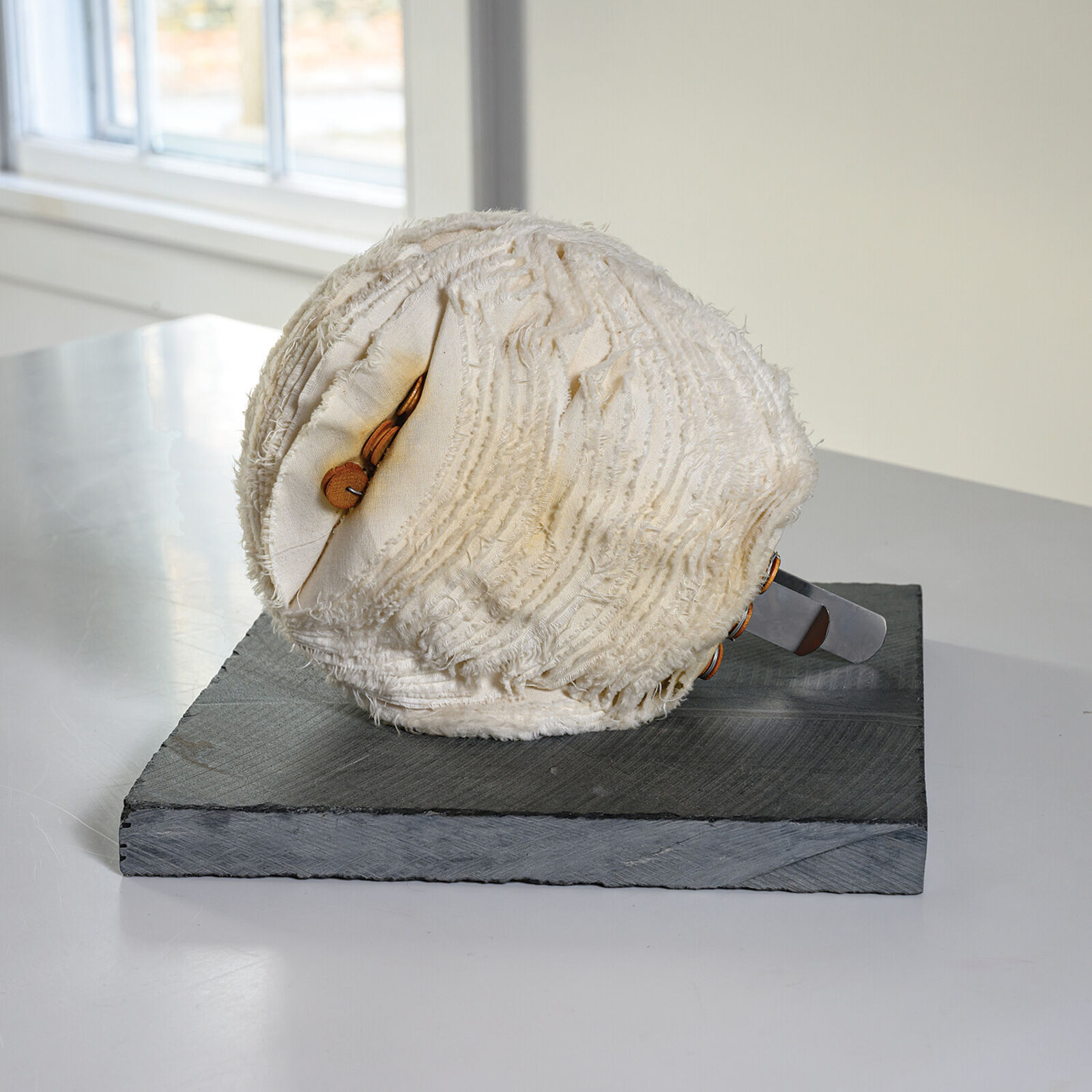 A white ball of yarn sitting on top of a table.