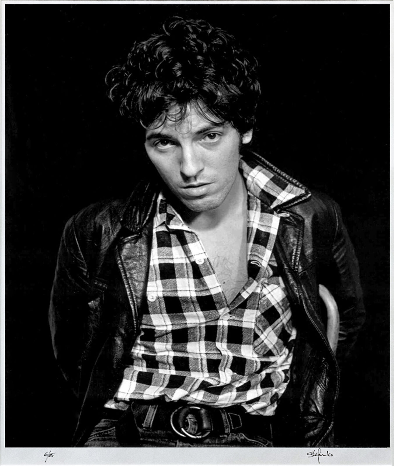 A black and white photo of a man in a plaid shirt.