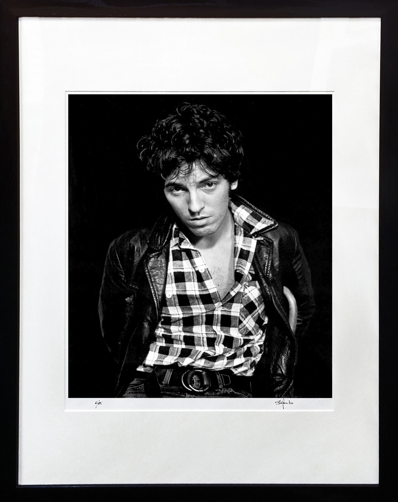 A black and white photo of a man in a plaid shirt.