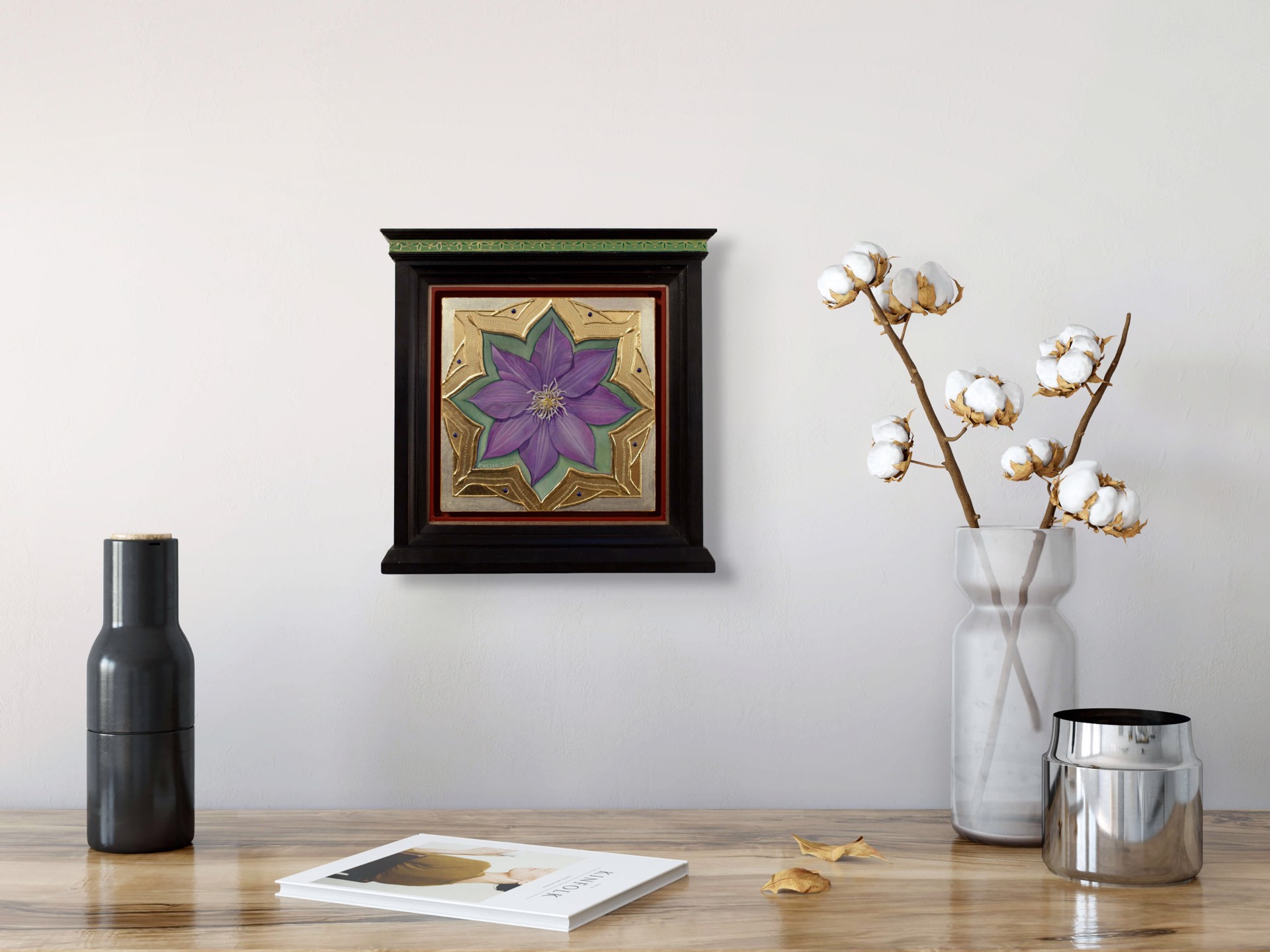 A purple flower set within an ornate gold frame on a red background.