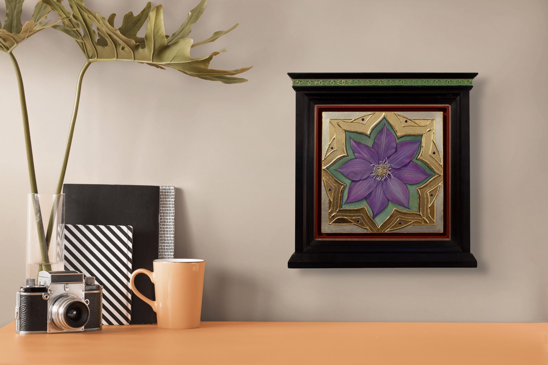 A purple flower set within an ornate gold frame on a red background.