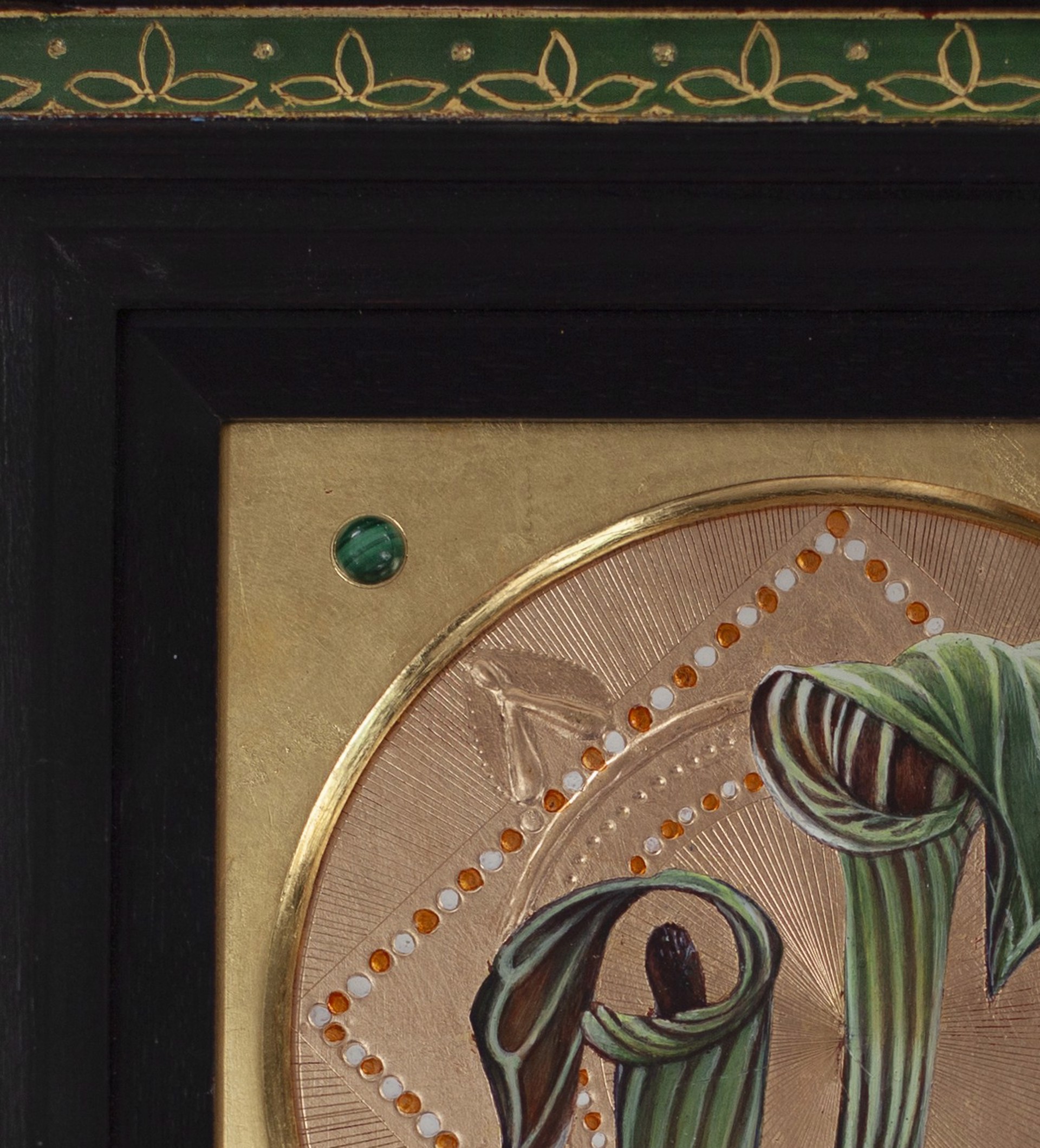 A picture of two flowers on a gold plate.