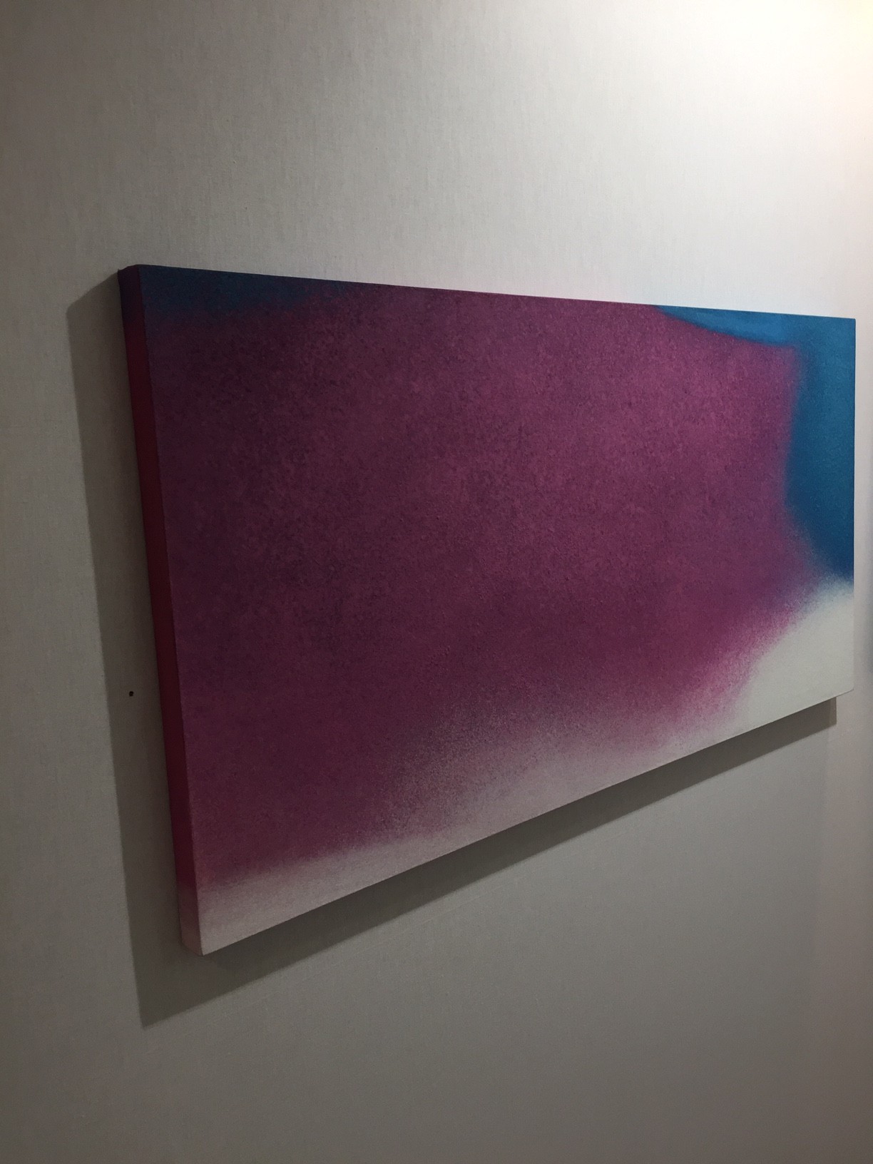 A painting hanging on a wall in a room.