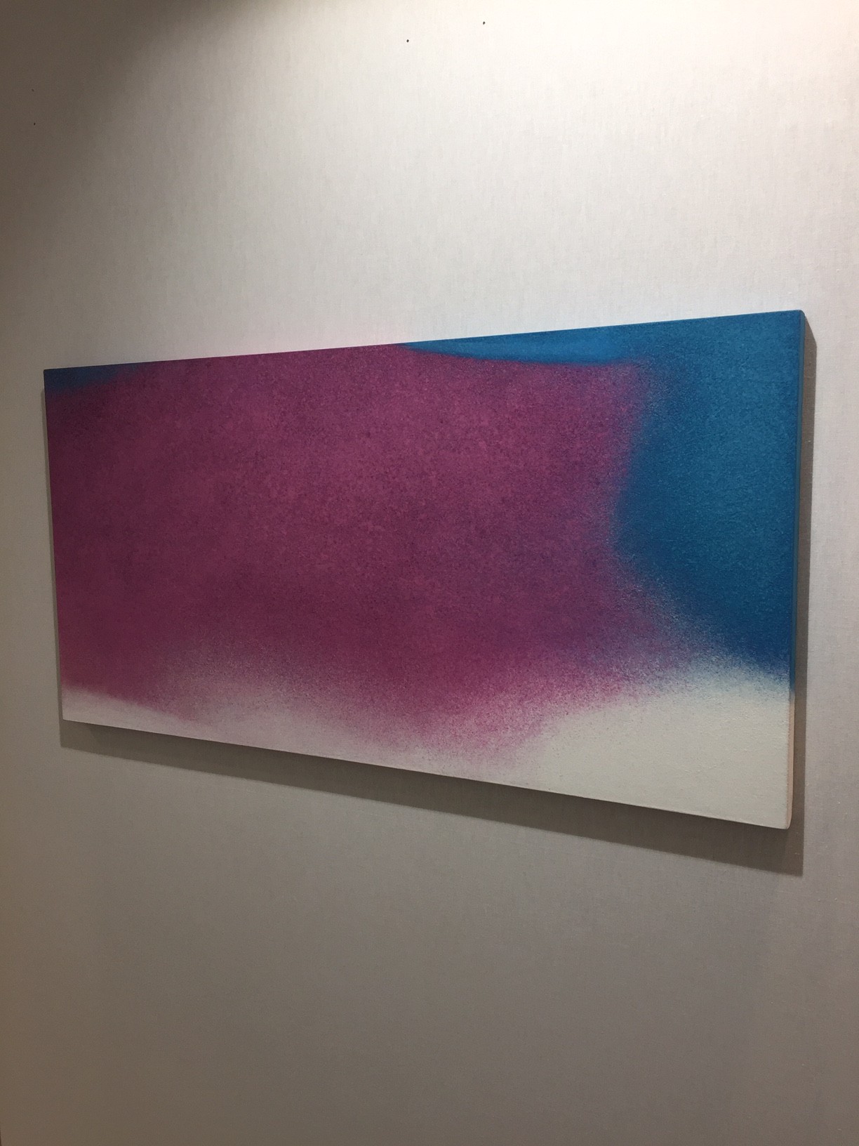 A painting hanging on a wall in a room.