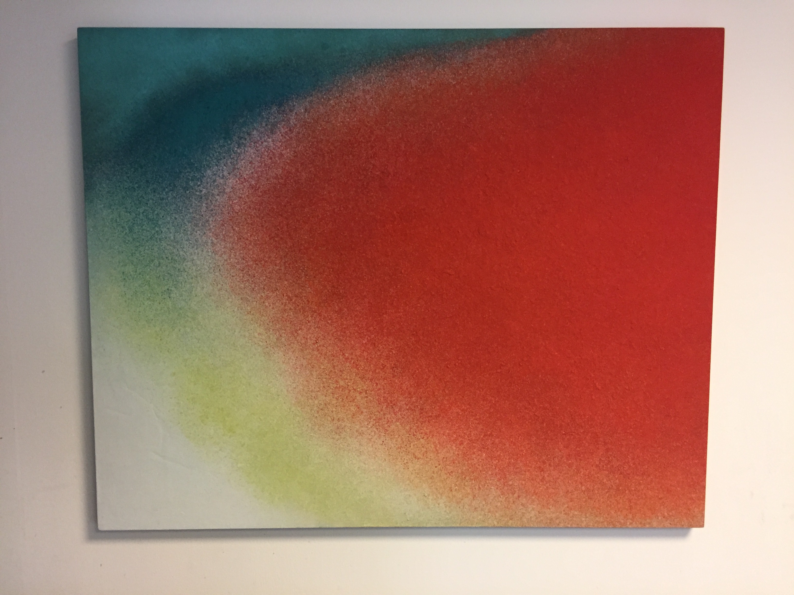 A painting on a white wall with a red and green background.