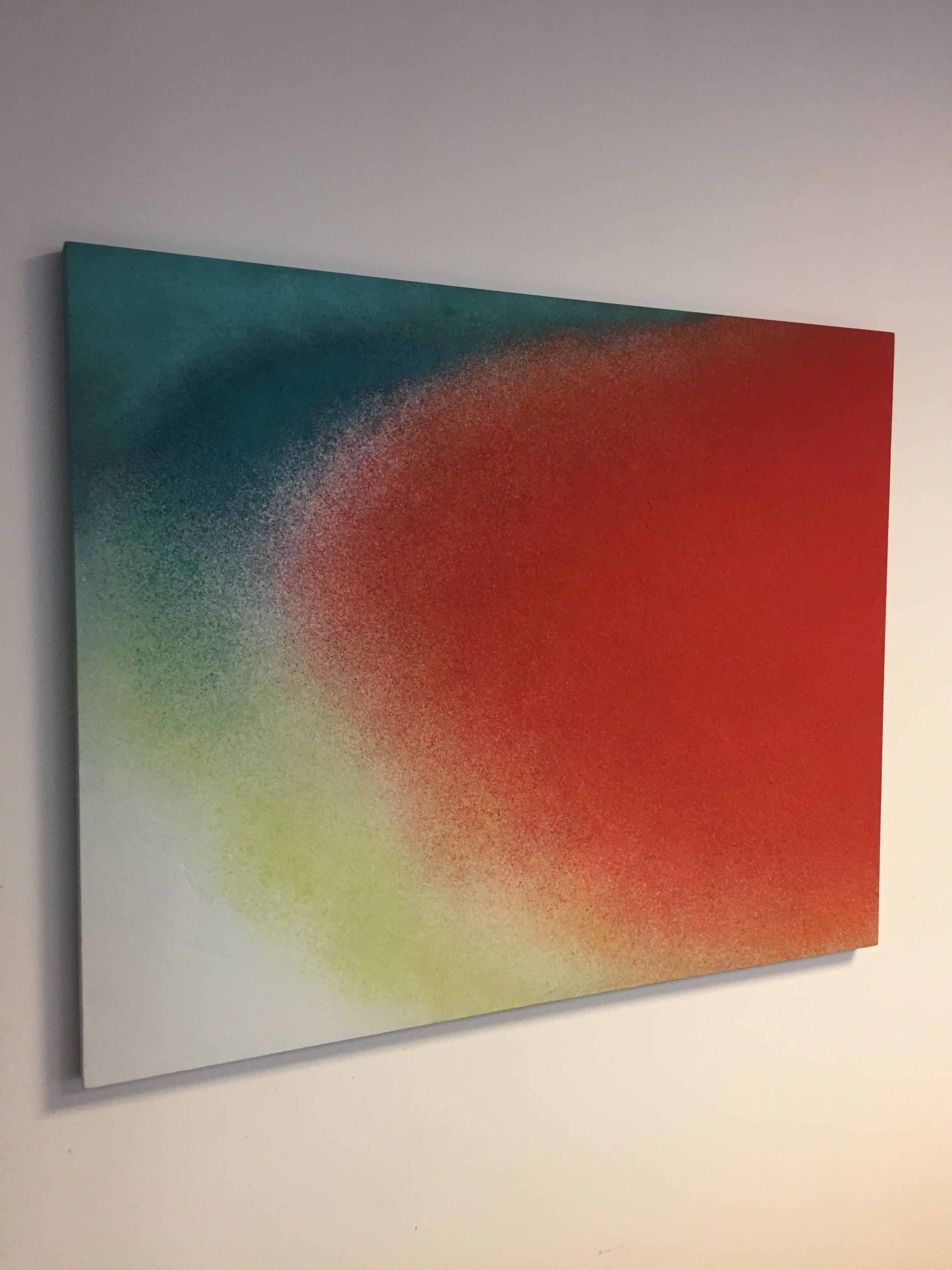 A painting on a white wall with a red and green background.