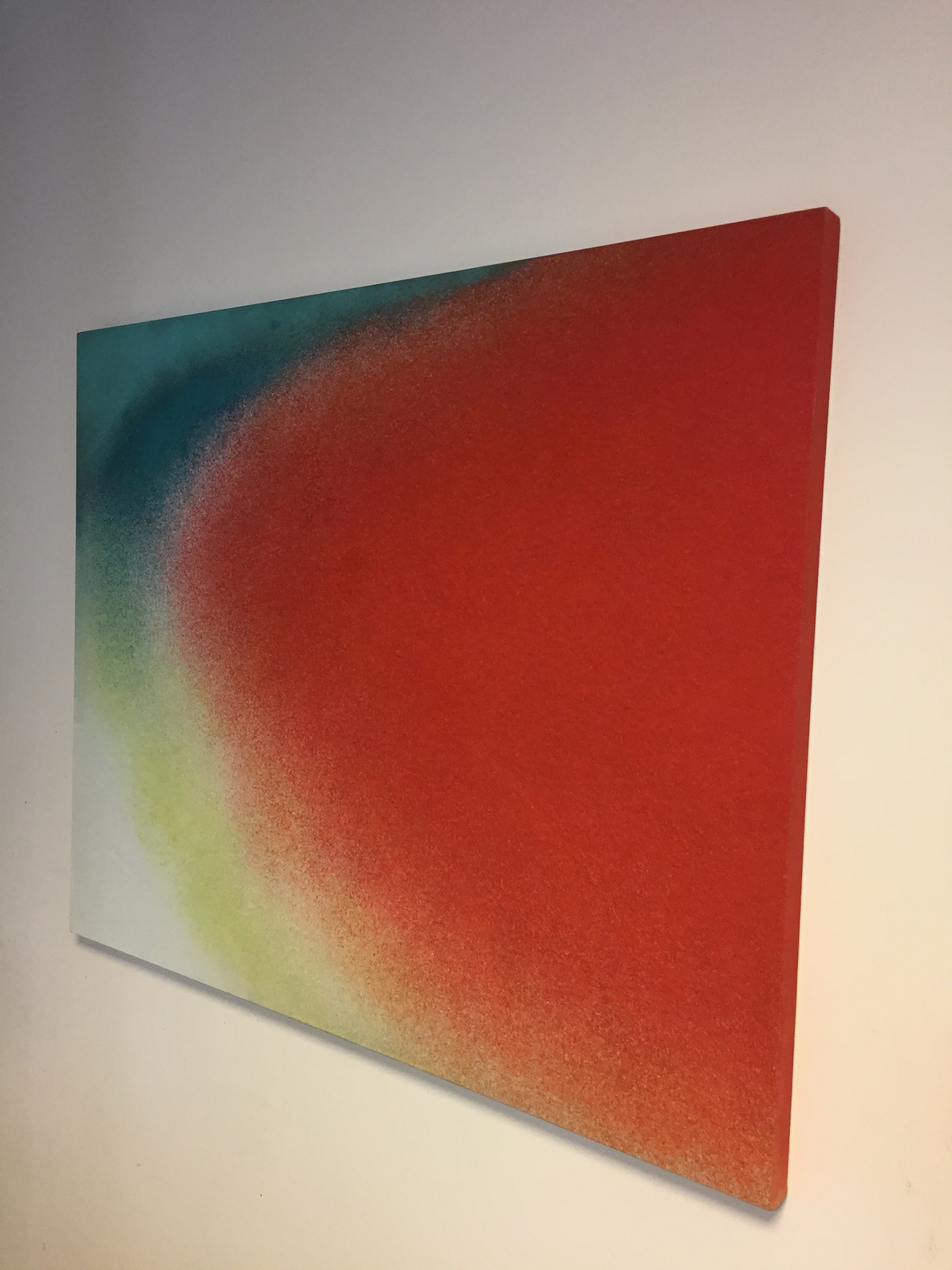A painting on a white wall with a red and green background.