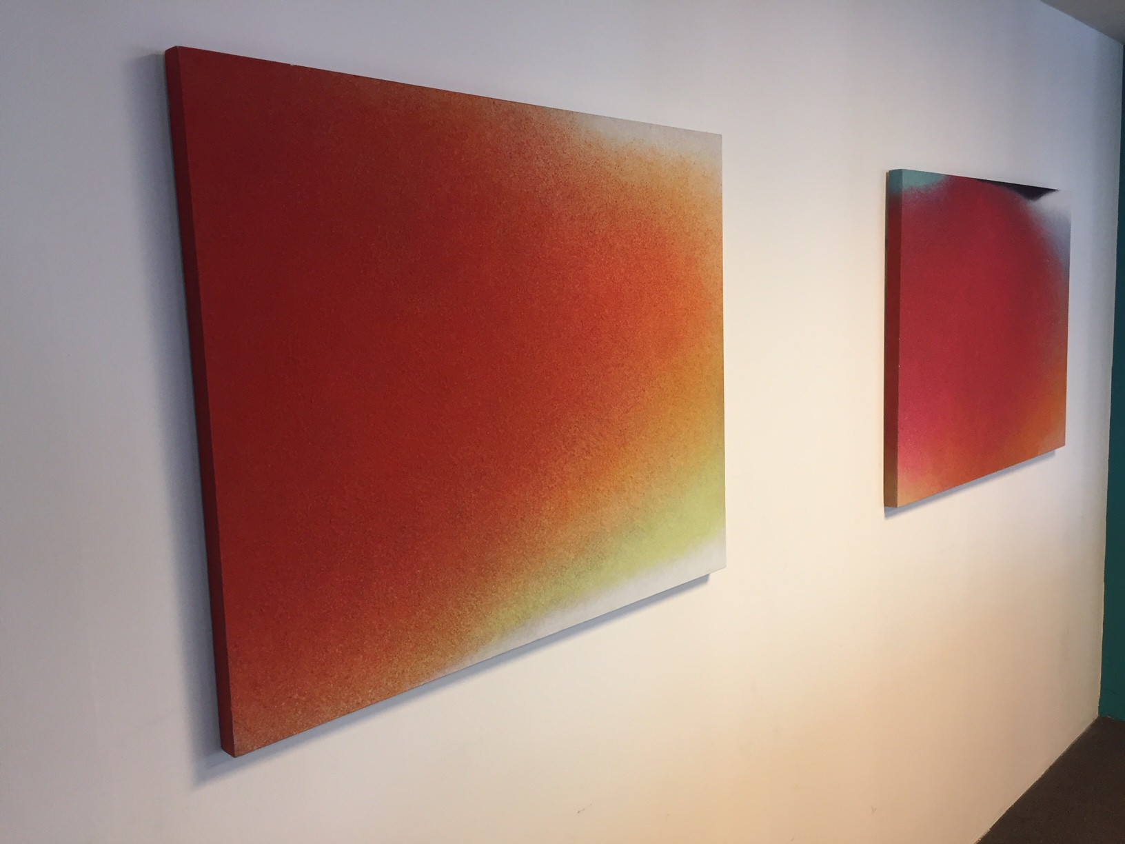 A painting on a white wall with a red and yellow background.