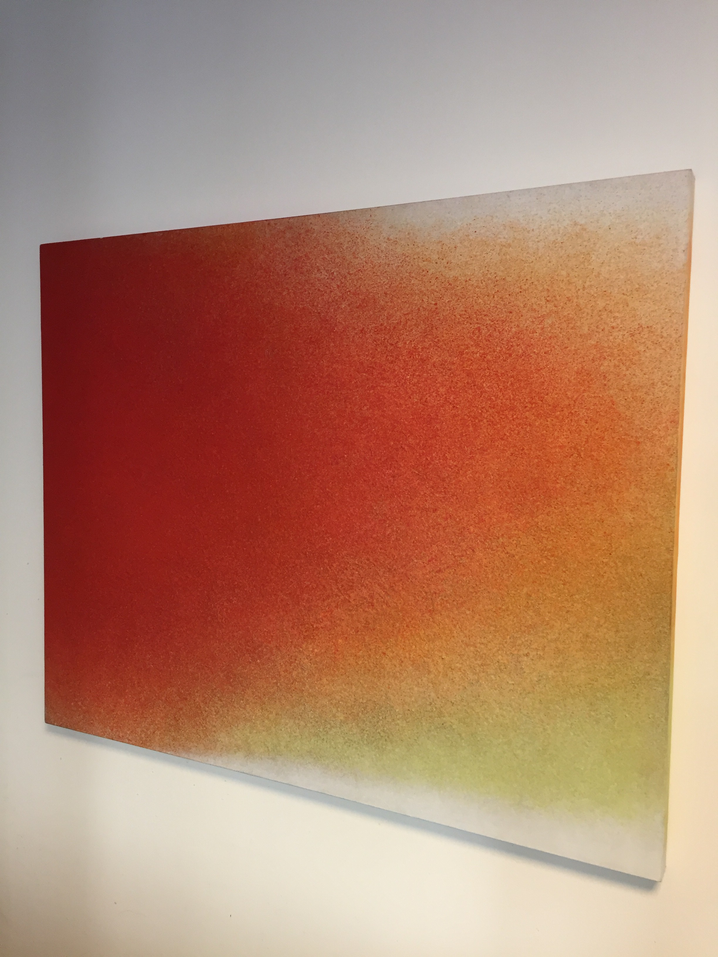 A painting on a white wall with a red and yellow background.