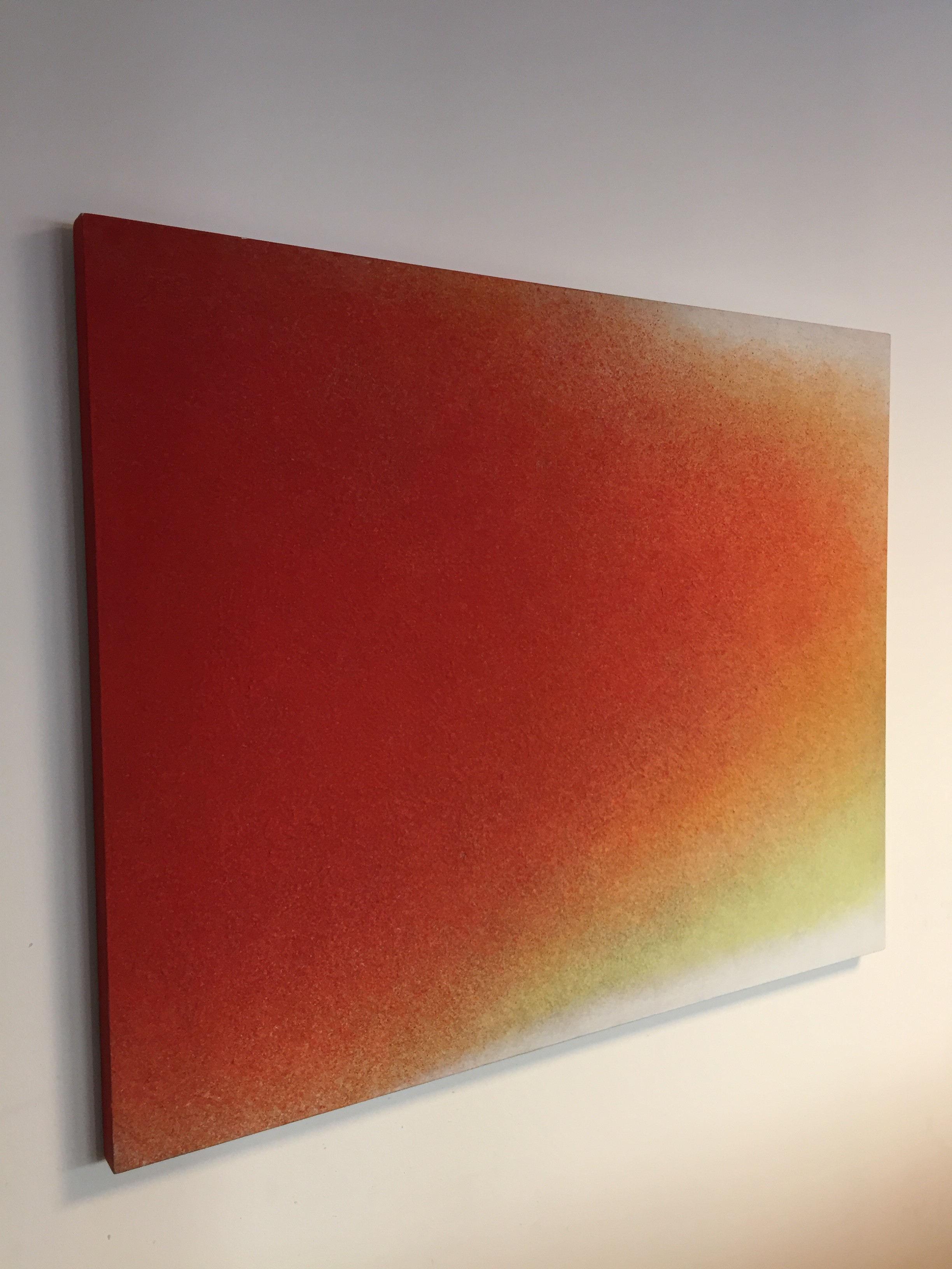 A painting on a white wall with a red and yellow background.