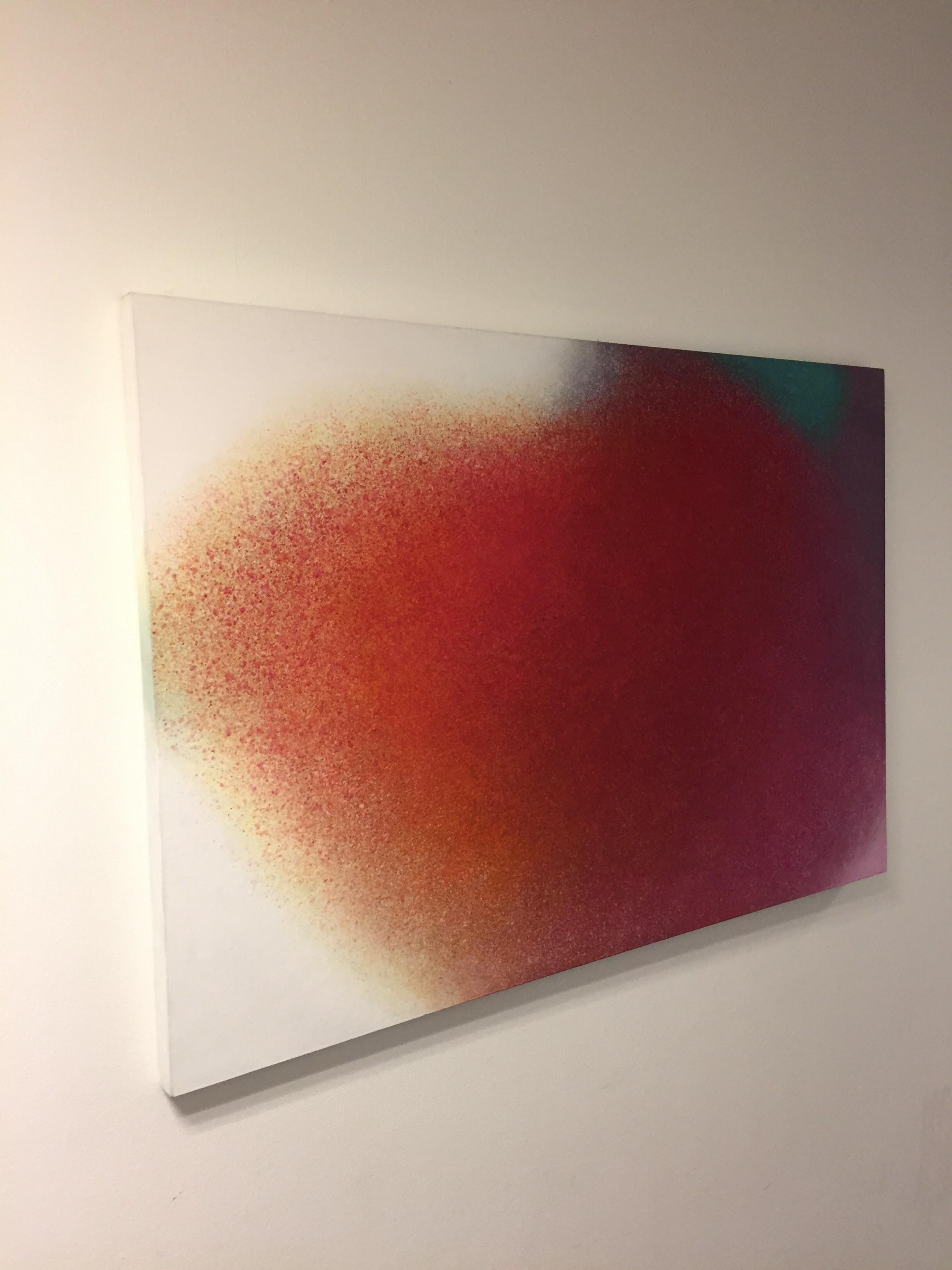 A painting on a white wall with a red and green background.