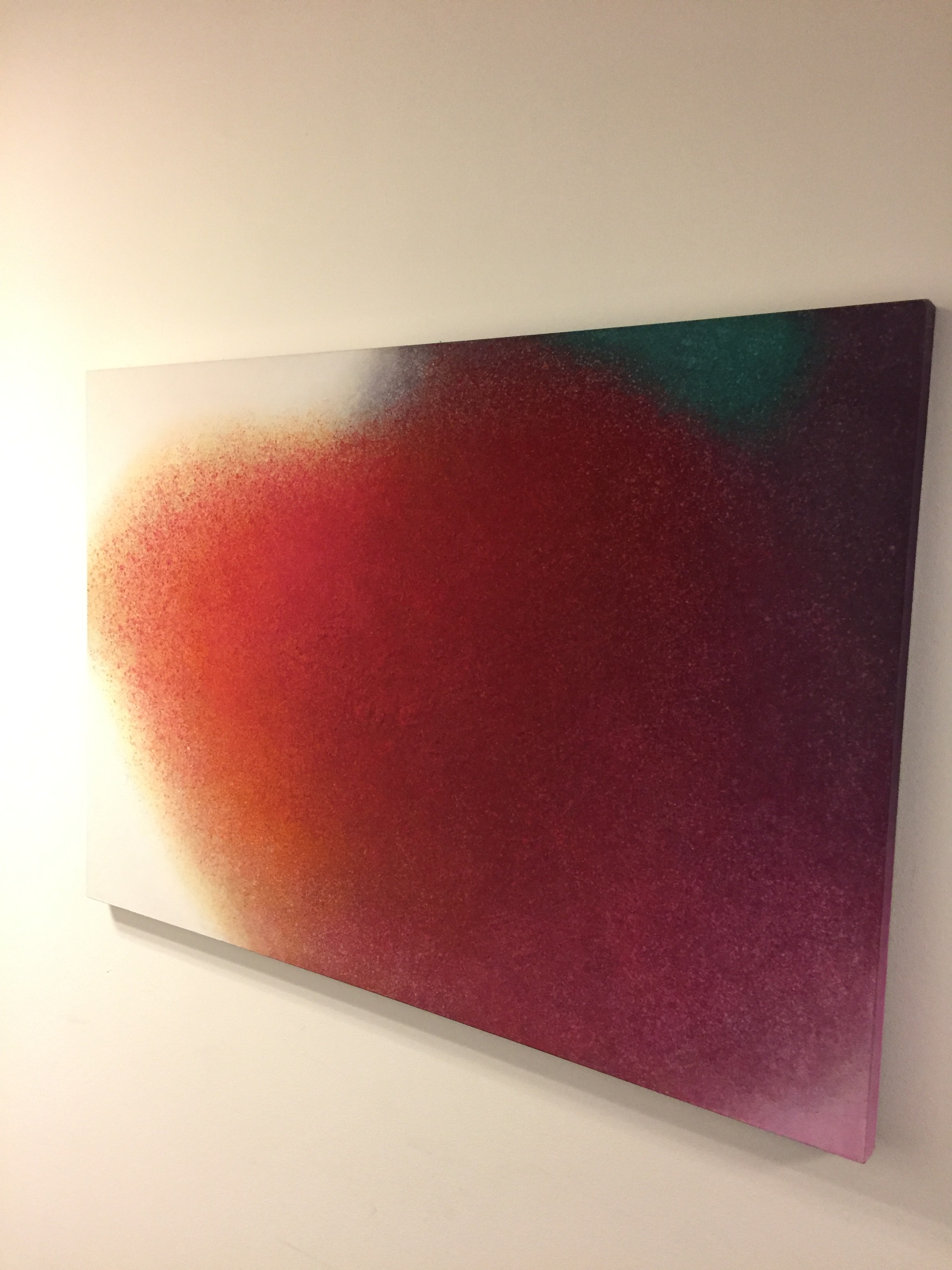 A painting on a white wall with a red and green background.