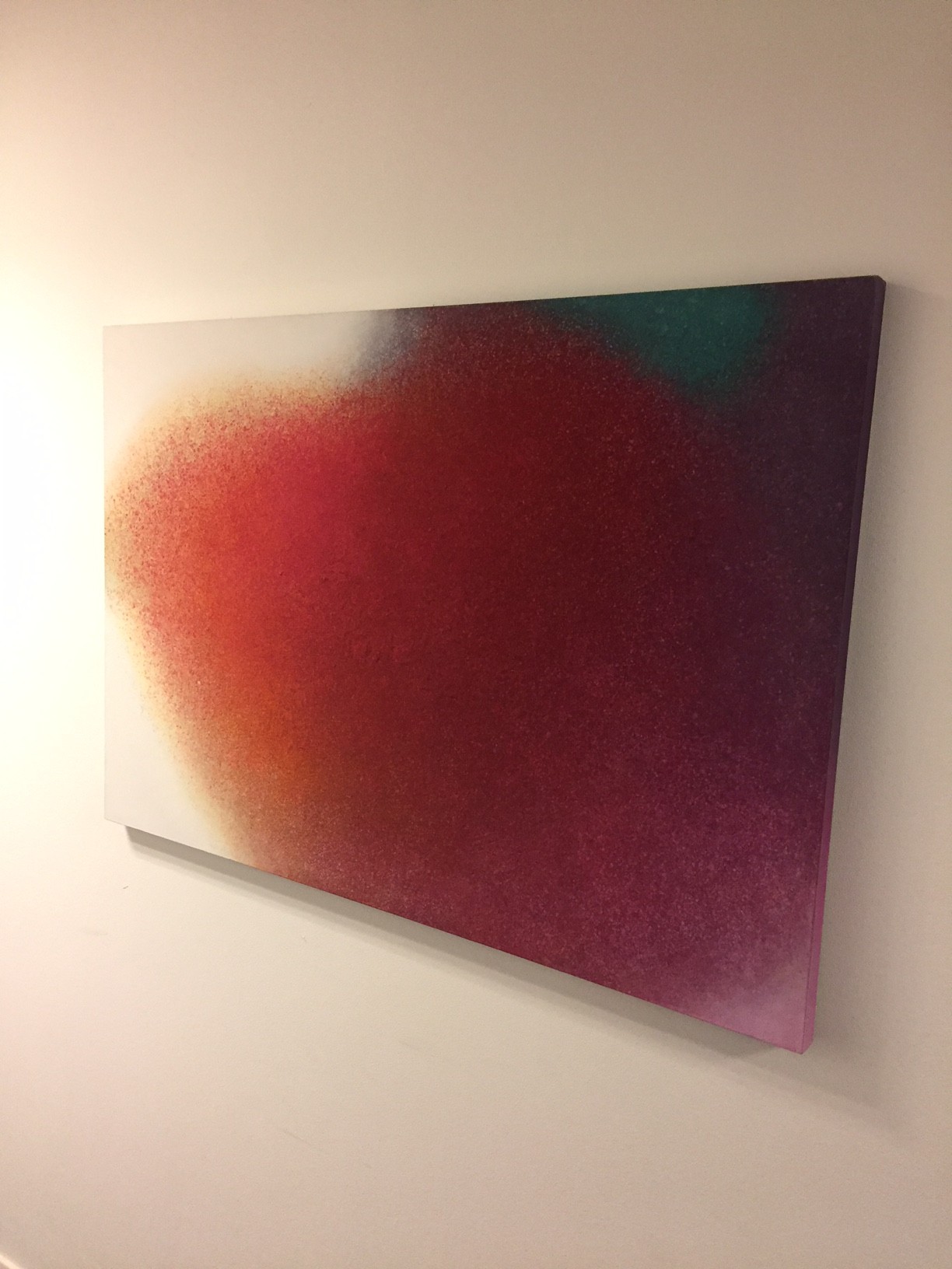 A painting on a white wall with a red and green background.