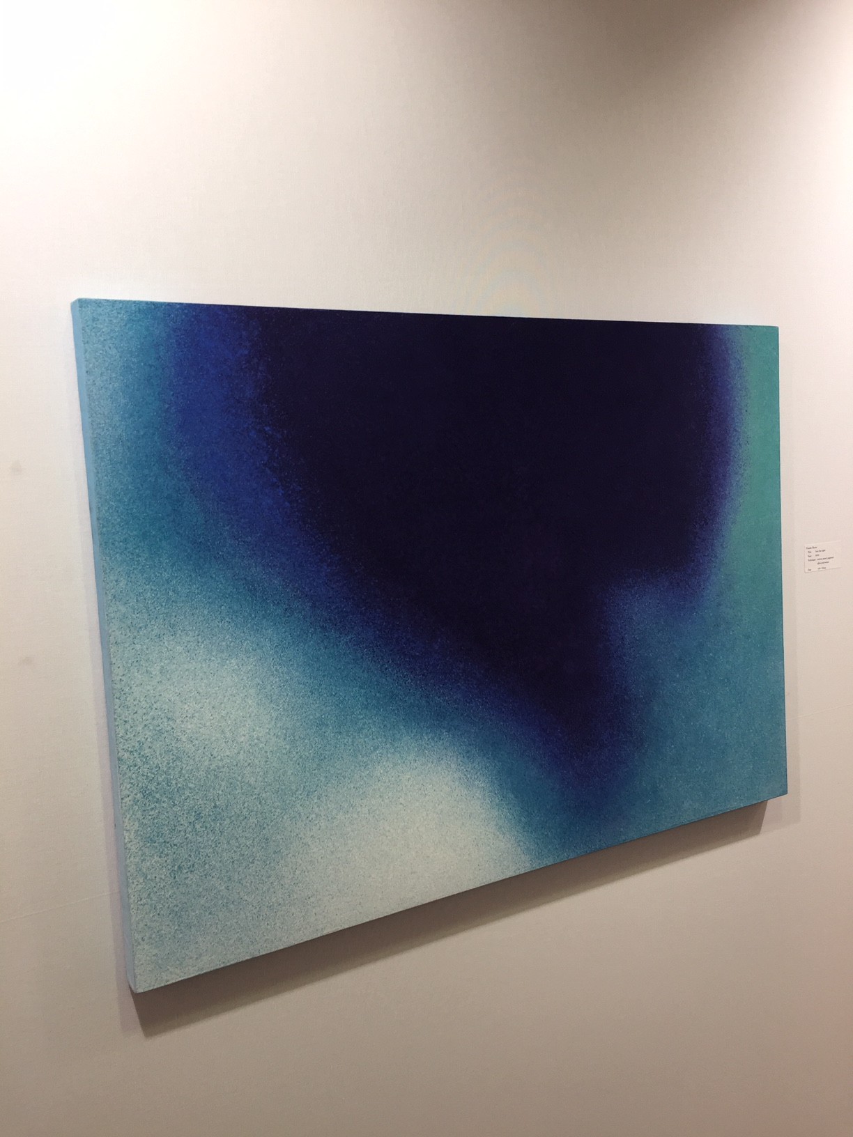 A painting hanging on a wall in a room.