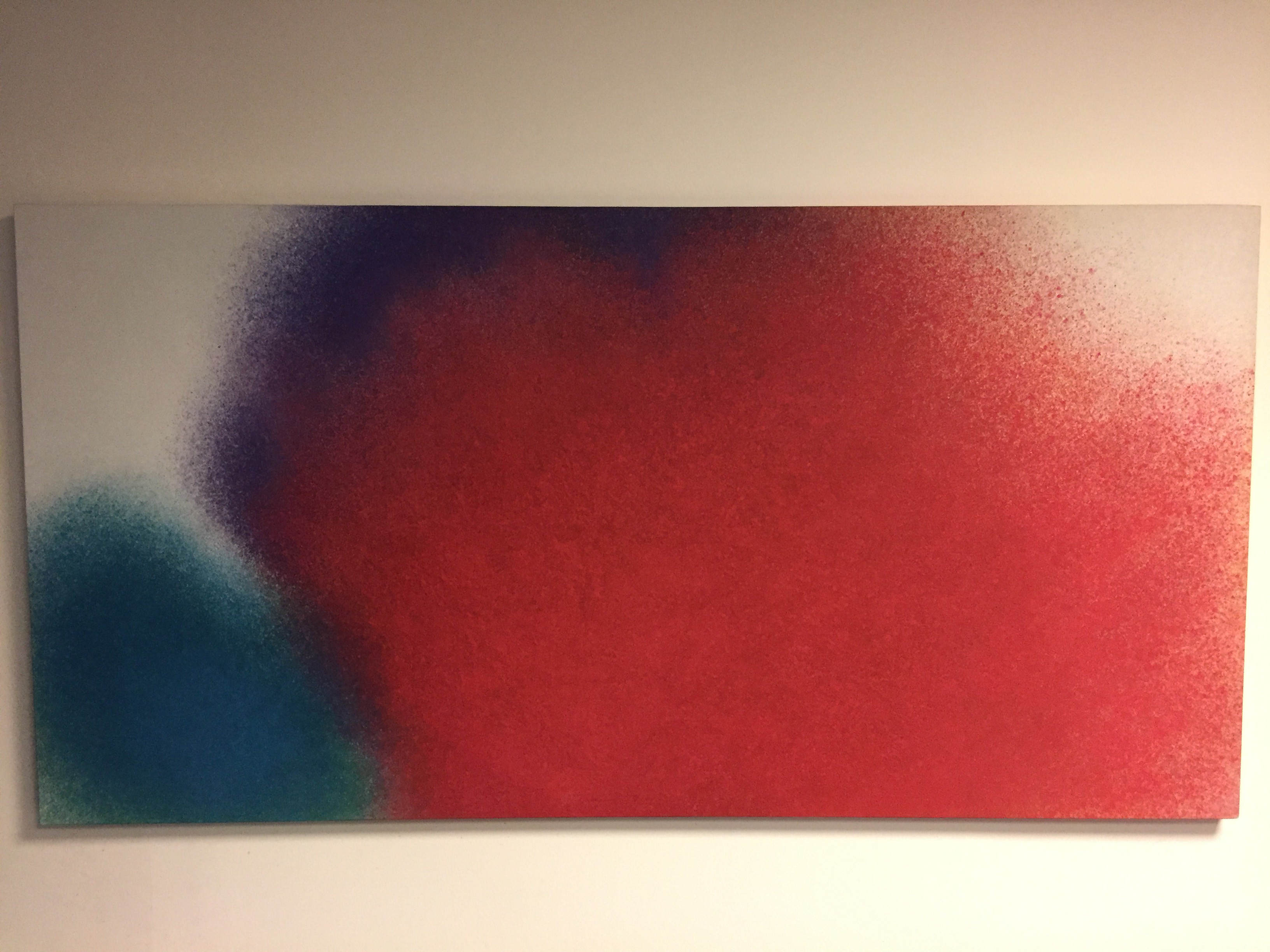 A minimalist abstract piece featuring a large red shape with blue and purple accents on a white background.