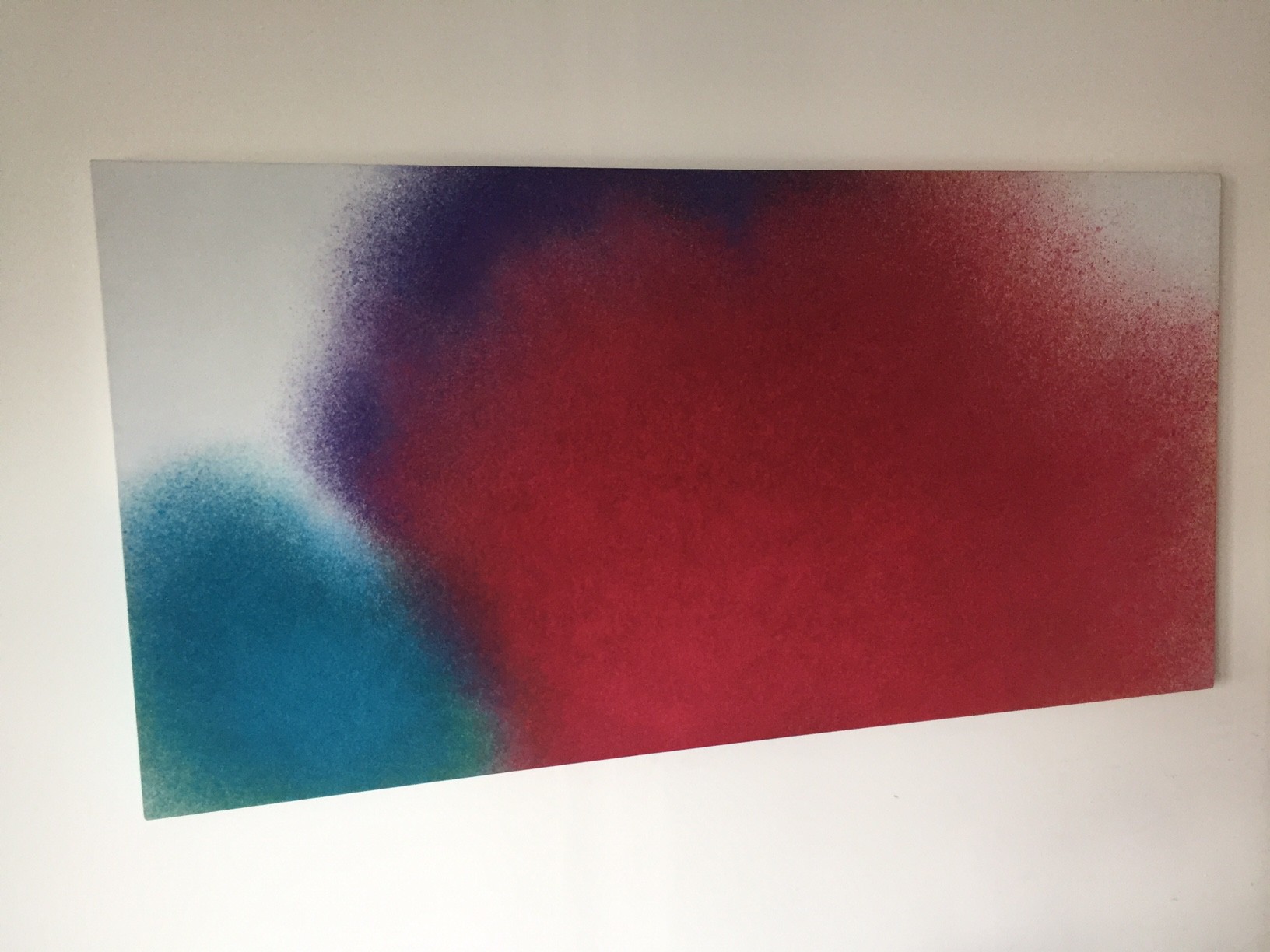 A minimalist abstract piece featuring a large red shape with blue and purple accents on a white background.