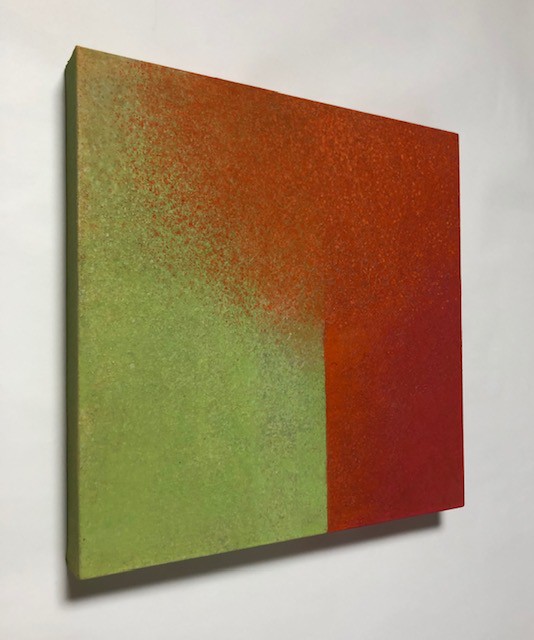 A painting on a white wall with a red and green color block.