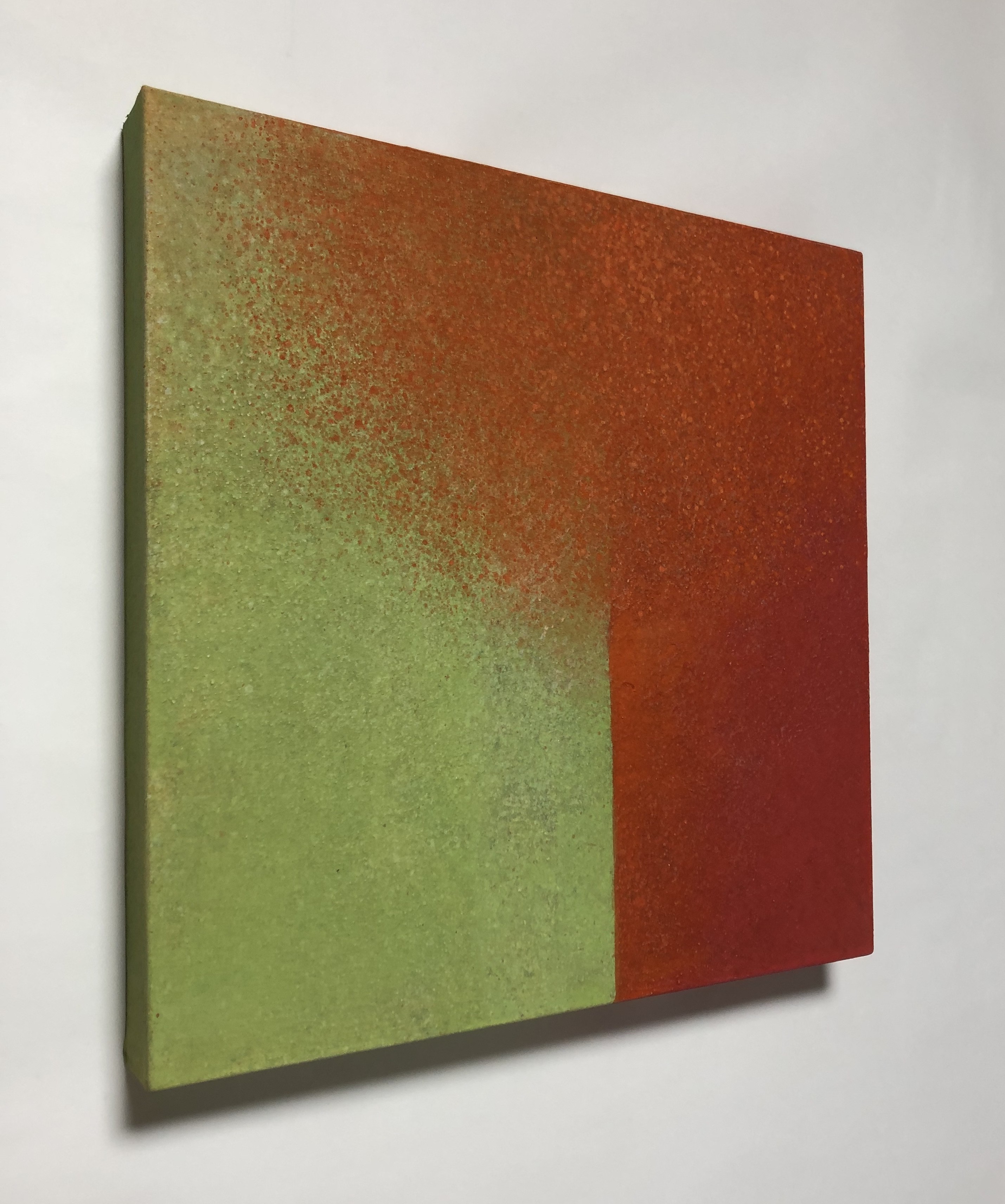 A painting on a white wall with a red and green color block.
