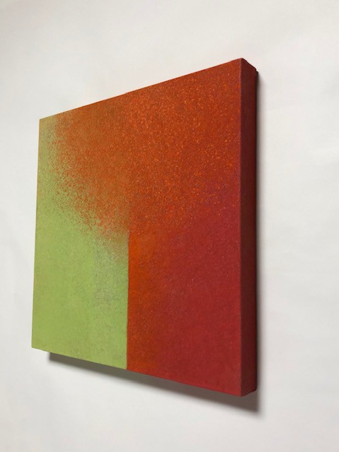 A painting on a white wall with a red and green color block.